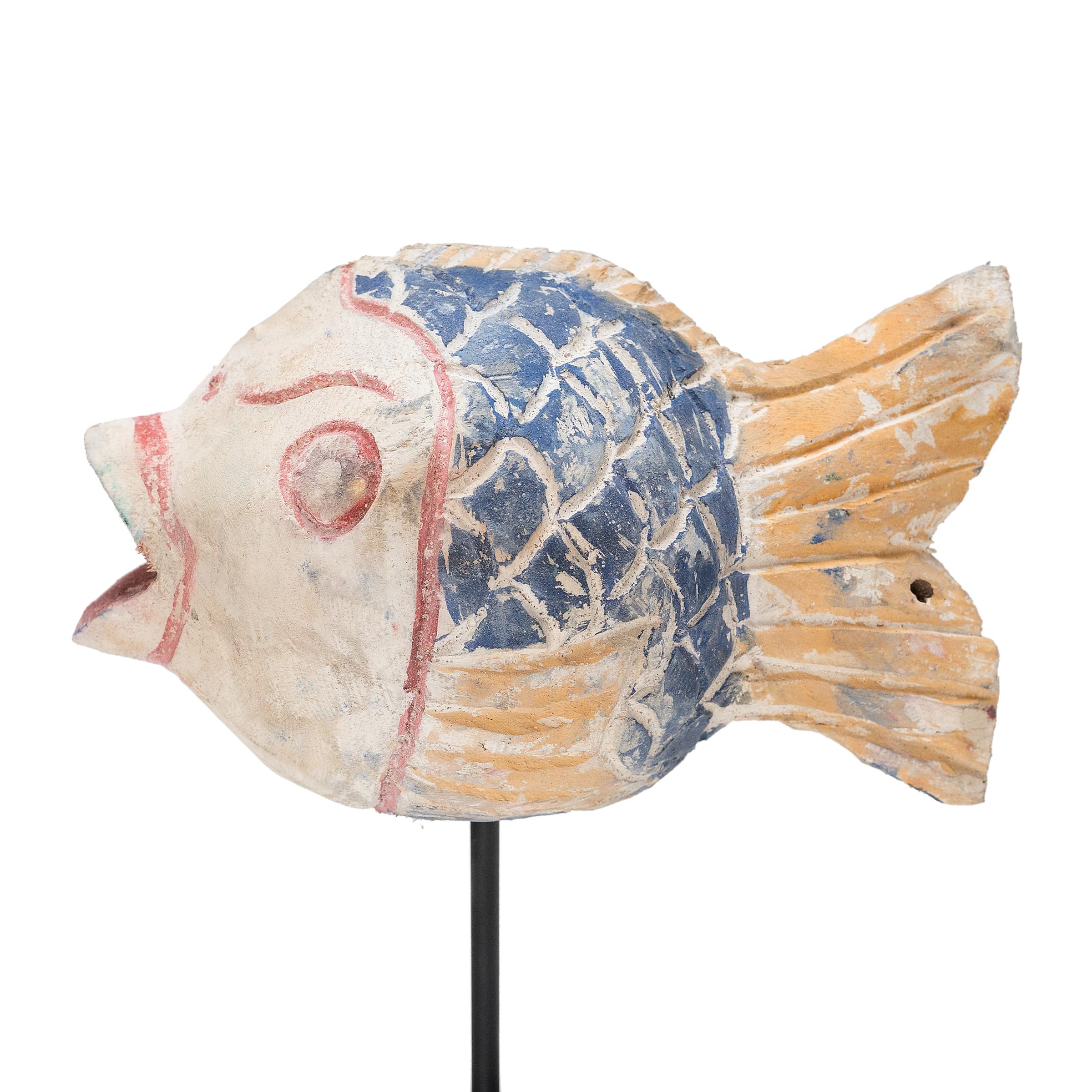 Hand-crafted from reclaimed wood, this artist-made koi is a traditional symbol of harmony and wealth. For Buddhists, such a fish represents a freedom from all restraints. The scales and fins on the squat, rounded body are highlighted with blue,