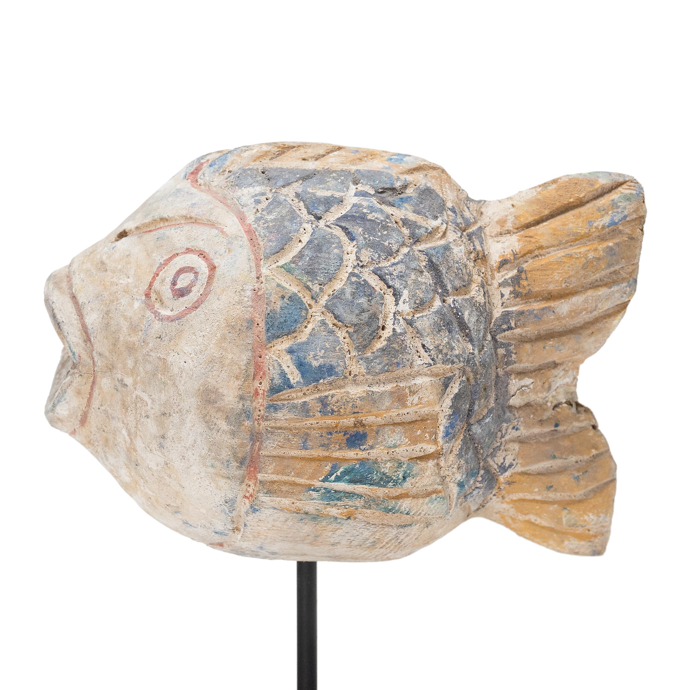 Hand-crafted from reclaimed wood, this artist-made koi is a traditional symbol of harmony and wealth. For Buddhists, such a fish represents a freedom from all restraints. The scales and fins on the squat, rounded body are highlighted with blue,