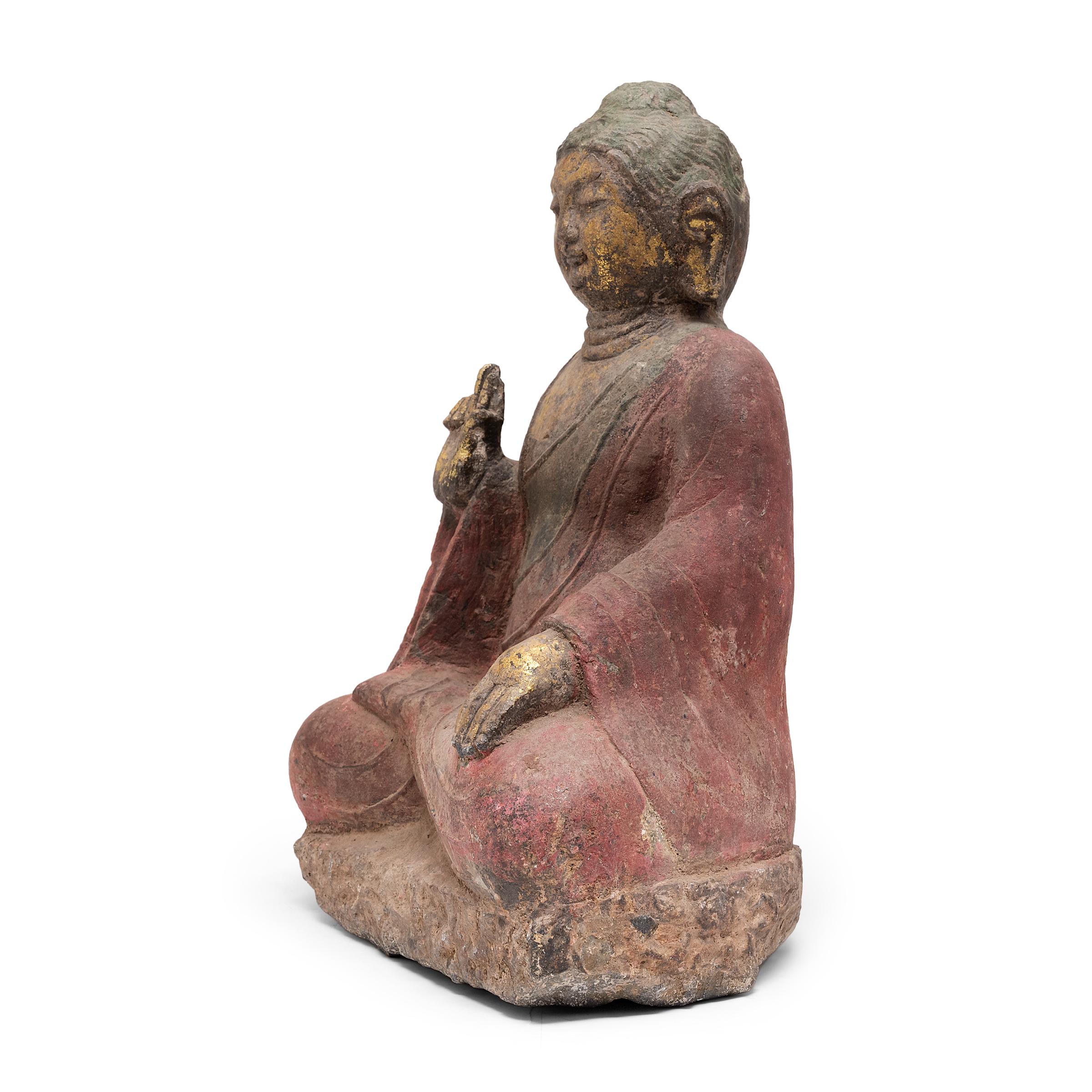 This carved stone figure depicts the historical Buddha, known also as Shaka, Shakyamuni, or Siddhartha Gautama. Seated in meditation with legs crossed in diamond position, the Buddha embodies virtues of wisdom and composure. His right hand is held