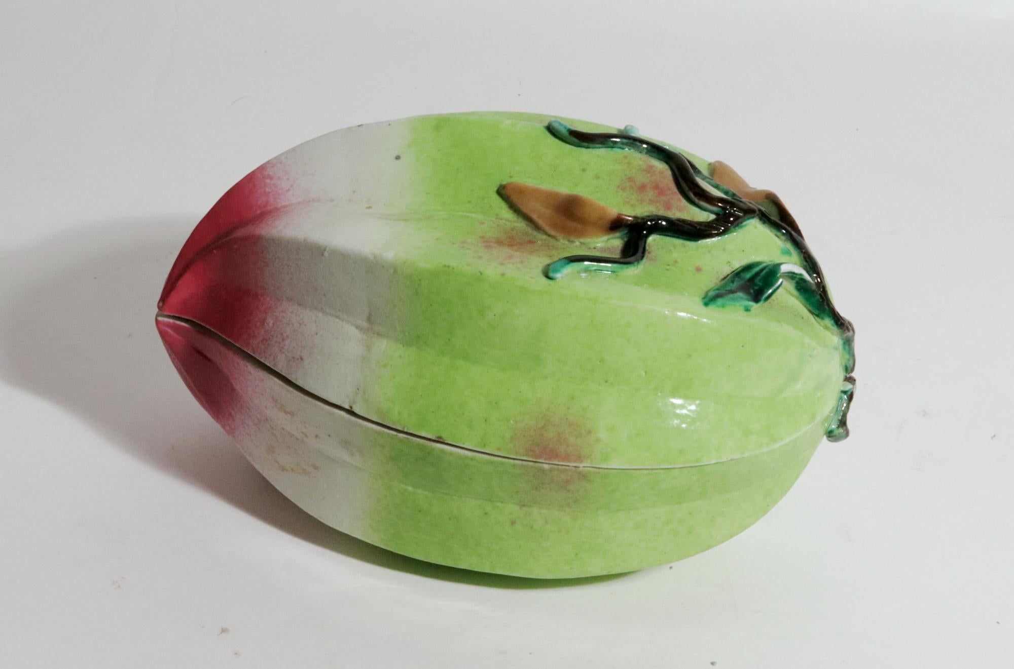 Frutero de porcelana china con forma de melocotón,
Siglo XIX.

La caja ovalada de porcelana china en dos partes está moldeada en forma de un gran melocotón.  Tiene un color naturalista en verdes y morados.  El interior en color azul aqua. El borde