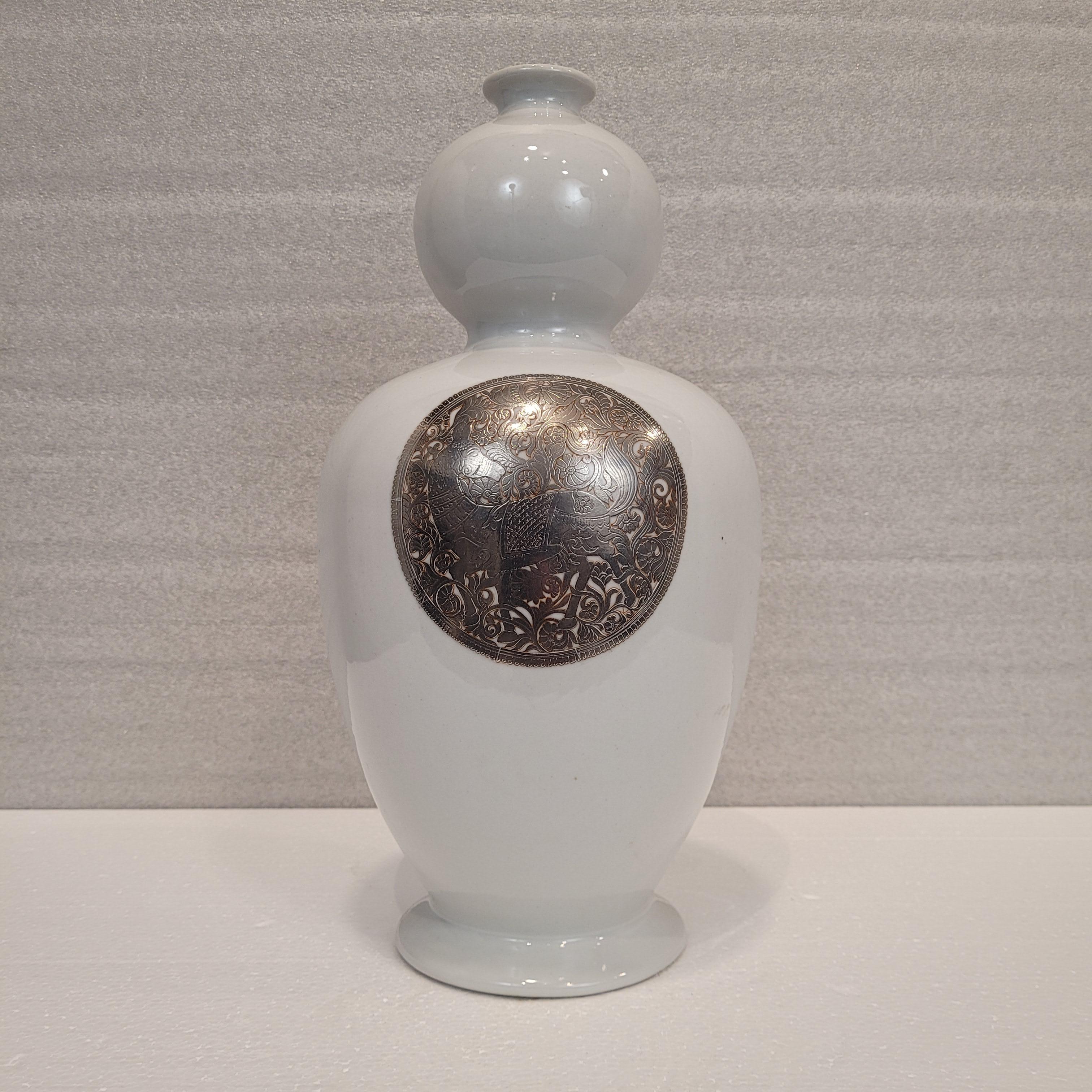 Exquisite und sehr raffinierte Vase aus chinesischem Porzellan, verziert mit einem Silbermedaillon, ein Werk, das die Tradition des orientalischen Porzellans mit einer zeitgenössischen und handwerklichen Neuinterpretation der französischen