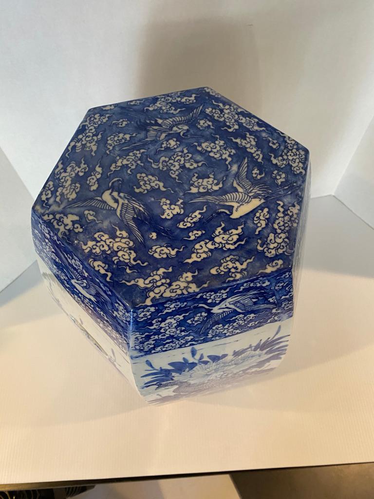 This blue and white Garden Seat is very special hand painted wit chrysanthemums on porcelain in a Hexagon shape having Chinese clouds and birds to the top openings to the sides for handles.