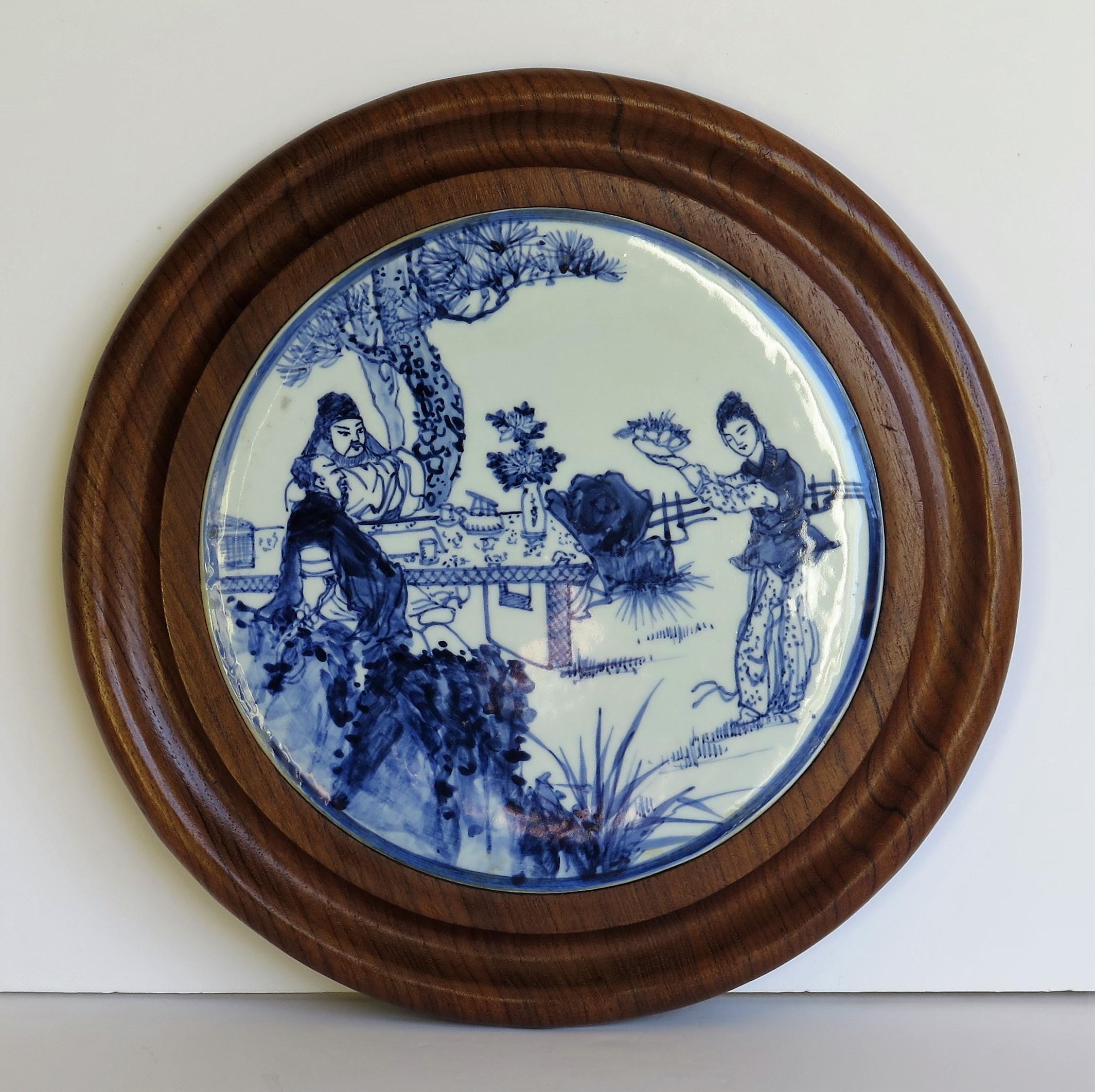 This is Chinese Export blue and white porcelain hand painted stand or picture in a turned walnut frame, dating to the early 20th century, circa 1930.

The central porcelain plaque is well potted with a glassy white glaze.

The porcelain has been