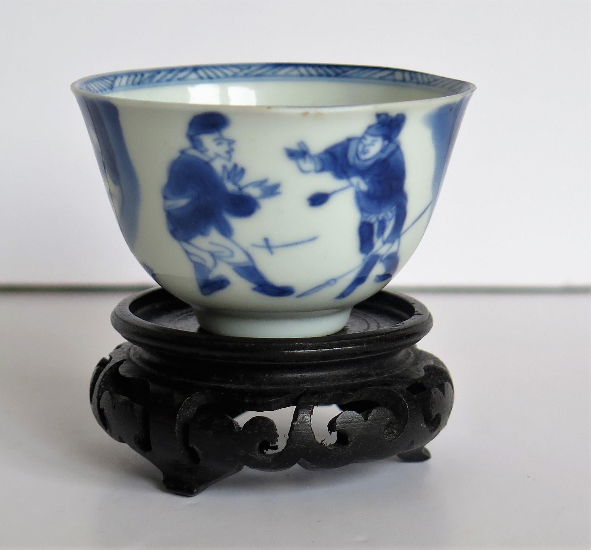 This is a beautifully hand painted Chinese porcelain blue and white Tea Bowl from the Qing, Kangxi period, 1662-1722, with a hand carved hard-wood Stand .

The tea bowl is very finely potted with a carefully cut base rim and a lovely rich glassy