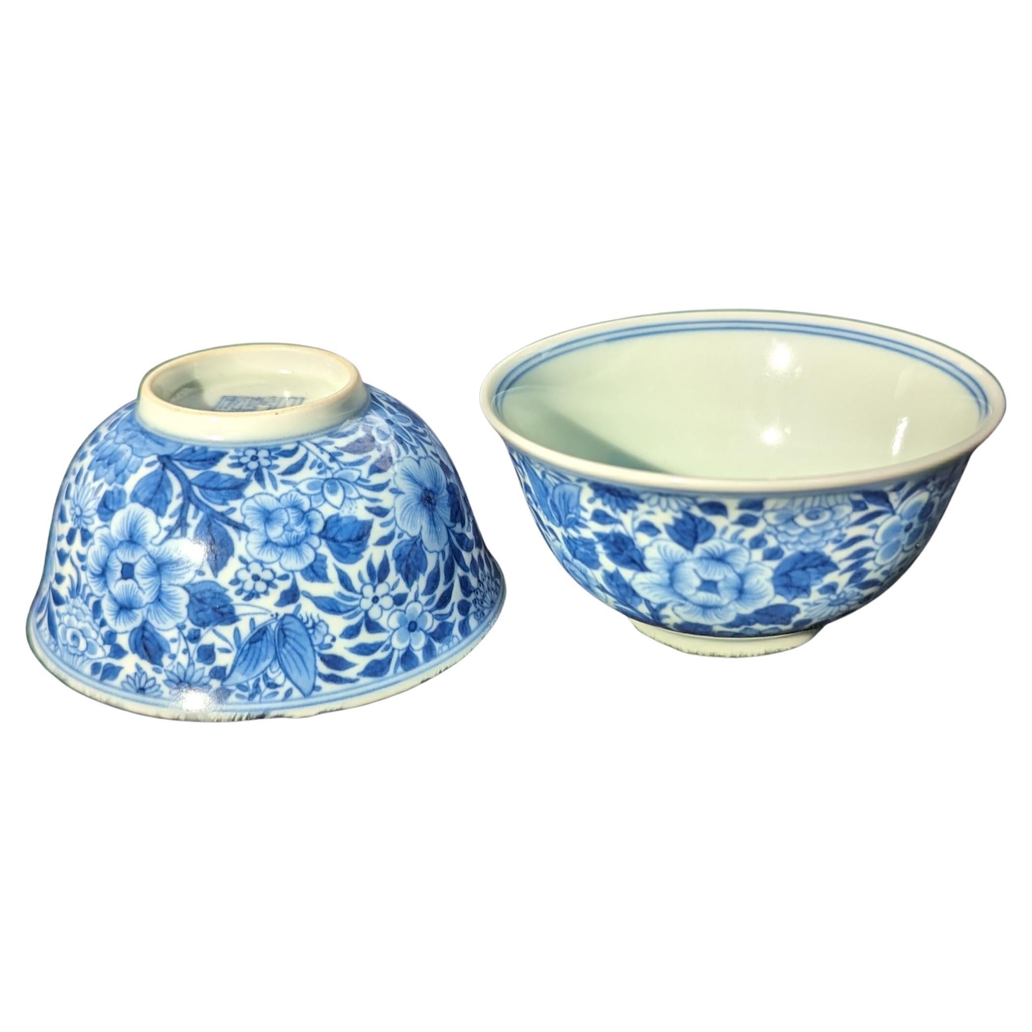 A pair of very fine Chinese porcelain small bowls, finely plotted hand decorated in underglaze blue and white in Qing mille fleur style, with apocryphal six character Qianlong mark within glazed footring in underglaze blue

This exquisite pair of
