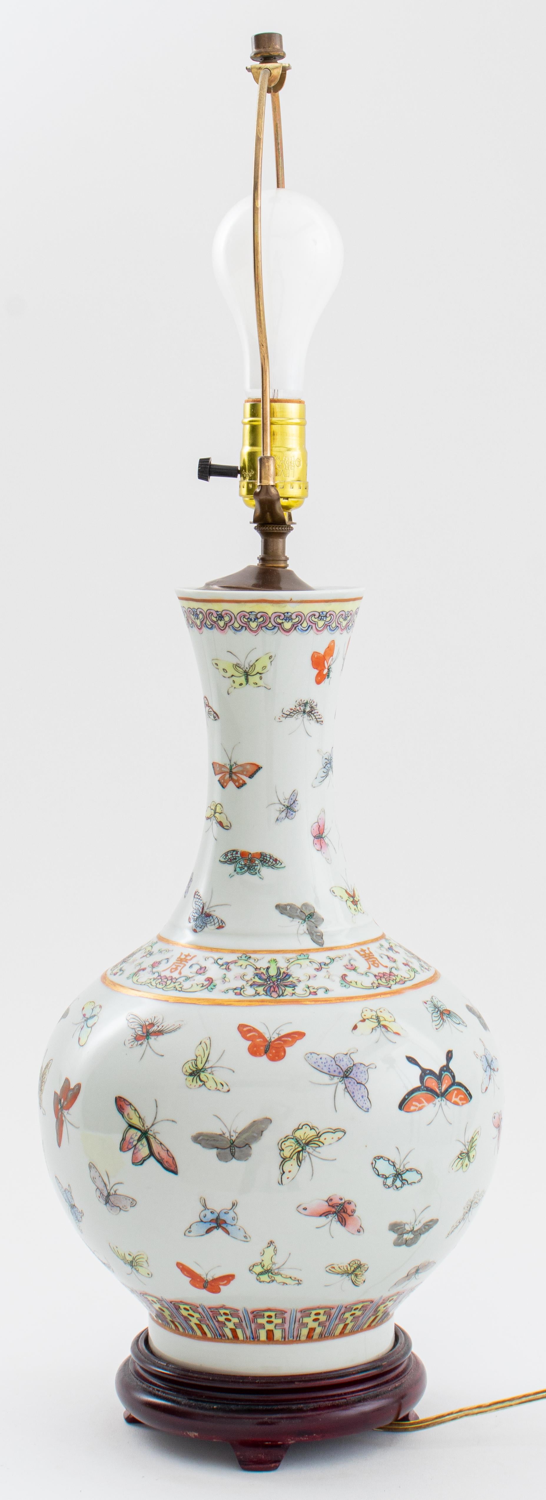 Chinese porcelain bottle vase hand-painted with gilt accents and a polychrome butterfly design, mounted as a lamp upon a hardwood base. Measures: 28