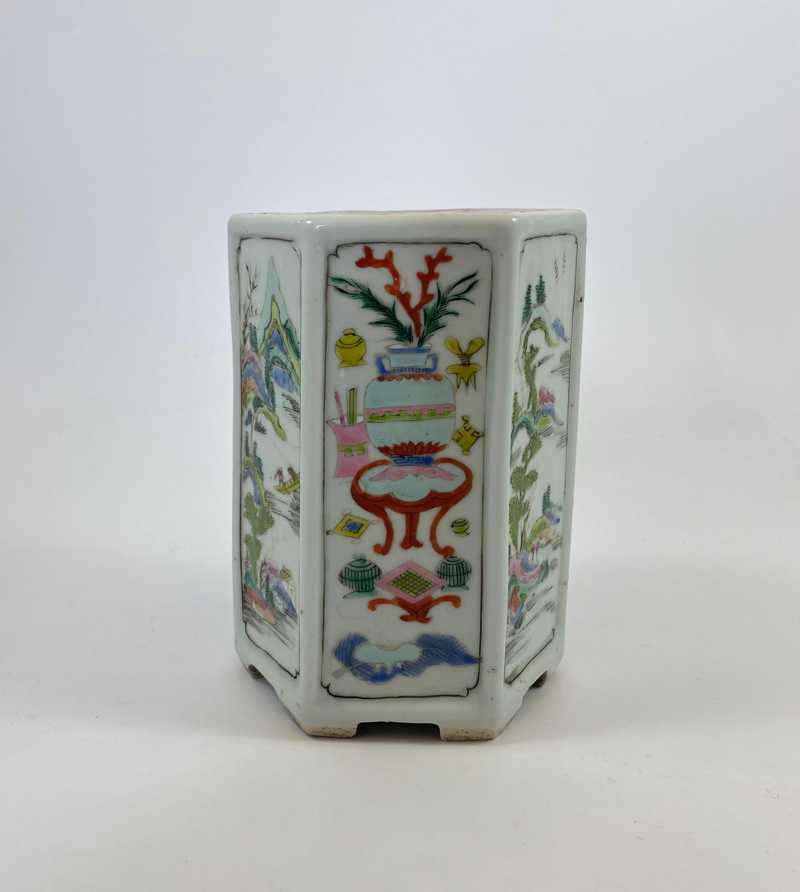 Chinese porcelain brush pot, c. 1730, Yongzheng Period. The hexagonal shaped pot, painted in famille rose enamels, with panels of mountainous river landscapes. Alternating, with panels of vases on tables, and stands, surrounded by smaller vases,