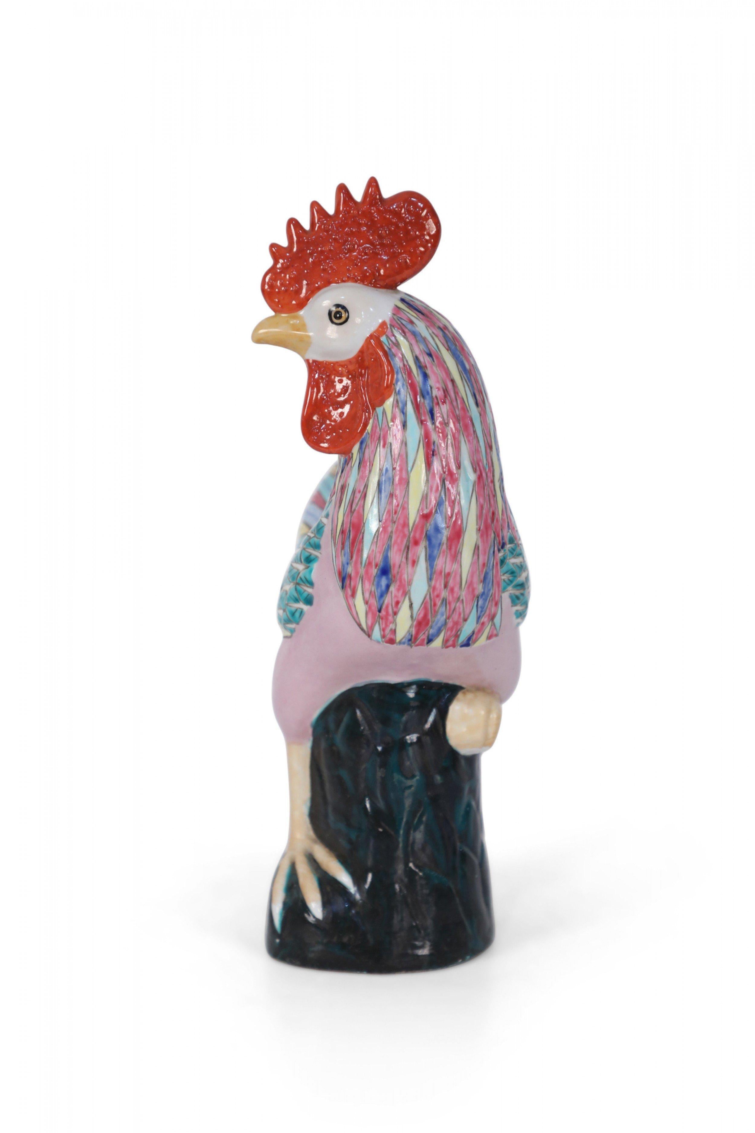 Antique Chinese porcelain chicken statue with colorful painted feathers perched on a black glazed rock.
    