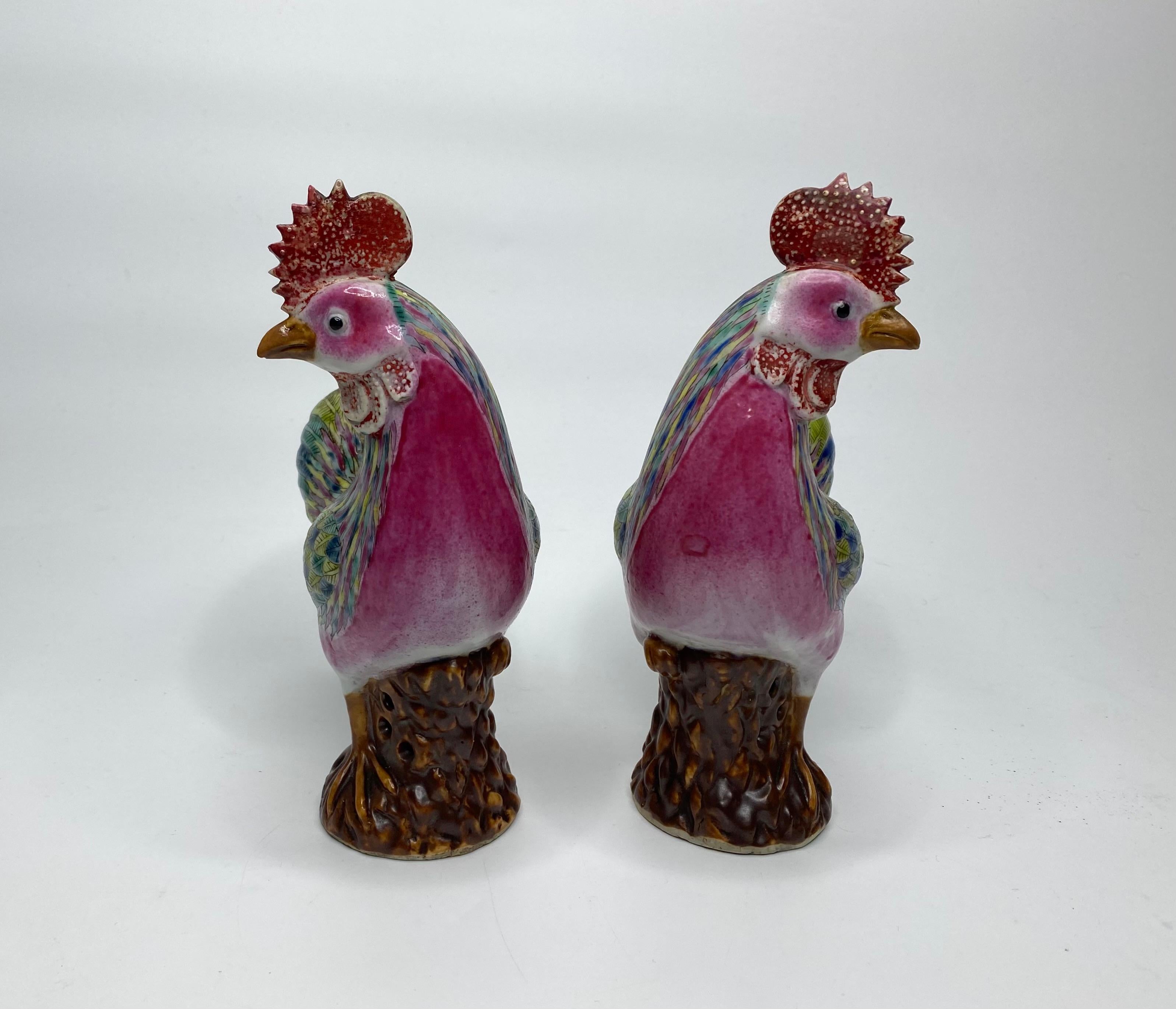 Pair of Chinese porcelain cockerels, c. 1890, Qing Dynasty. Both cockerels modelled standing on rocky bases, and their boldly decorated feathers in famille rose enamels.
Their combs and wattles painted in overglaze red enamel.
Height – 21 cm, 8