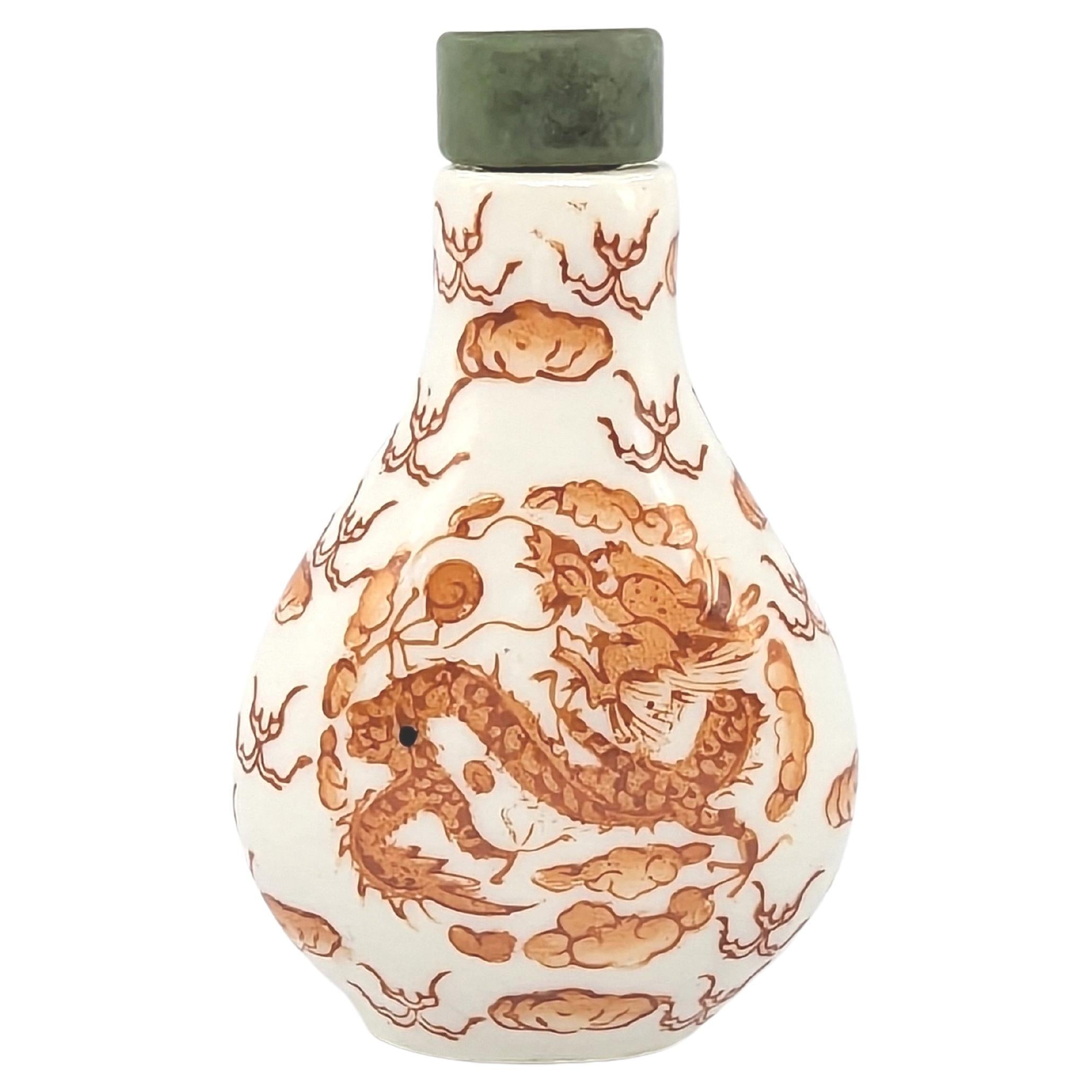 A Chinese porcelain snuff bottle, with a four claw dragon in clouds in iron red to each side, and two character red Qianlong mark to bottom

weight: 38 Grams
circa:  early to mid 20th Century 
