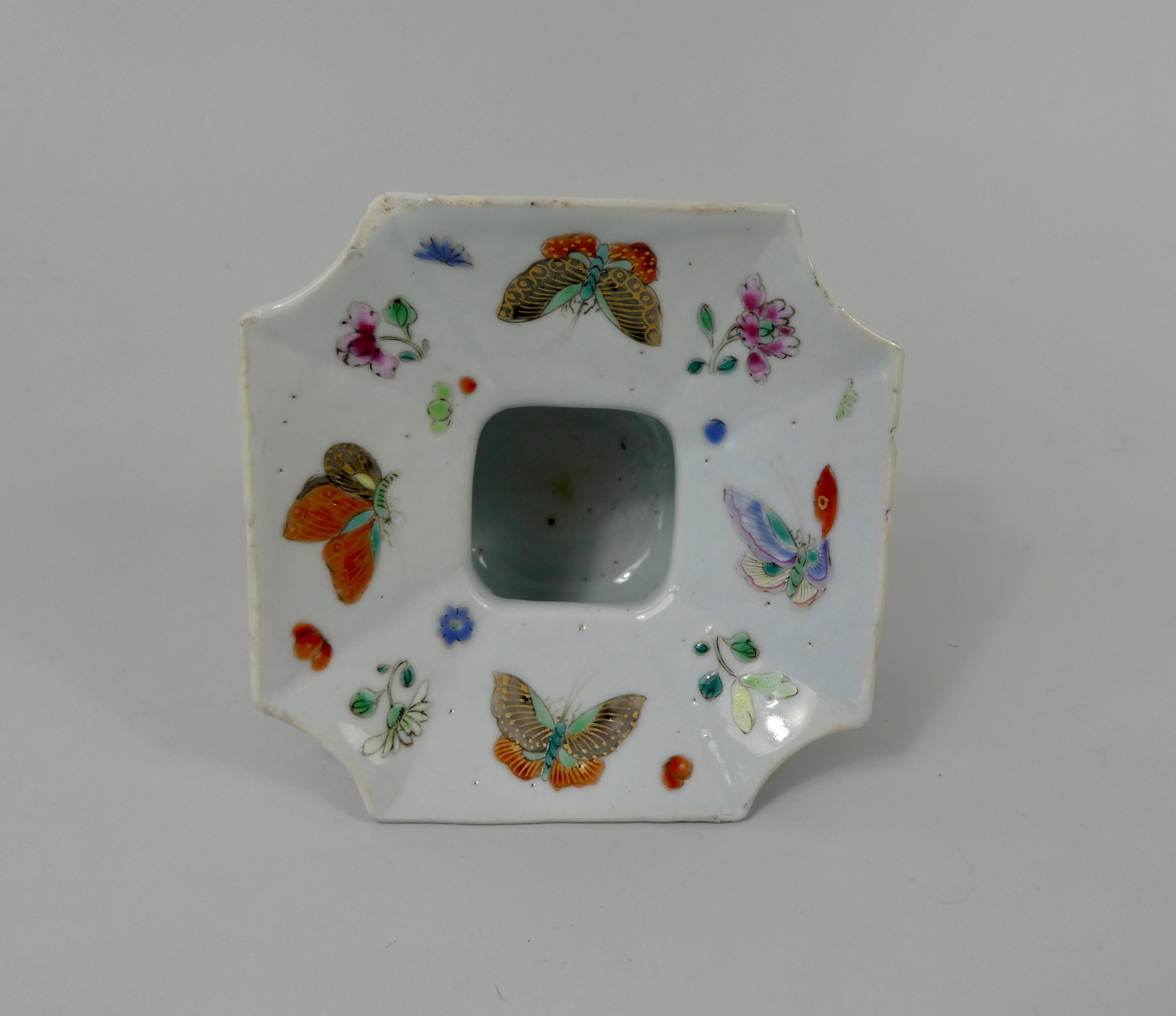 Chinese porcelain cuspidor, circa 1730, Qianlong Period. The squared form vessel, with canted corners, painted in fencai or famille rose enamels, with butterflies, amongst sprays of flowers. Having a loop handle, painted with a stylised flowering