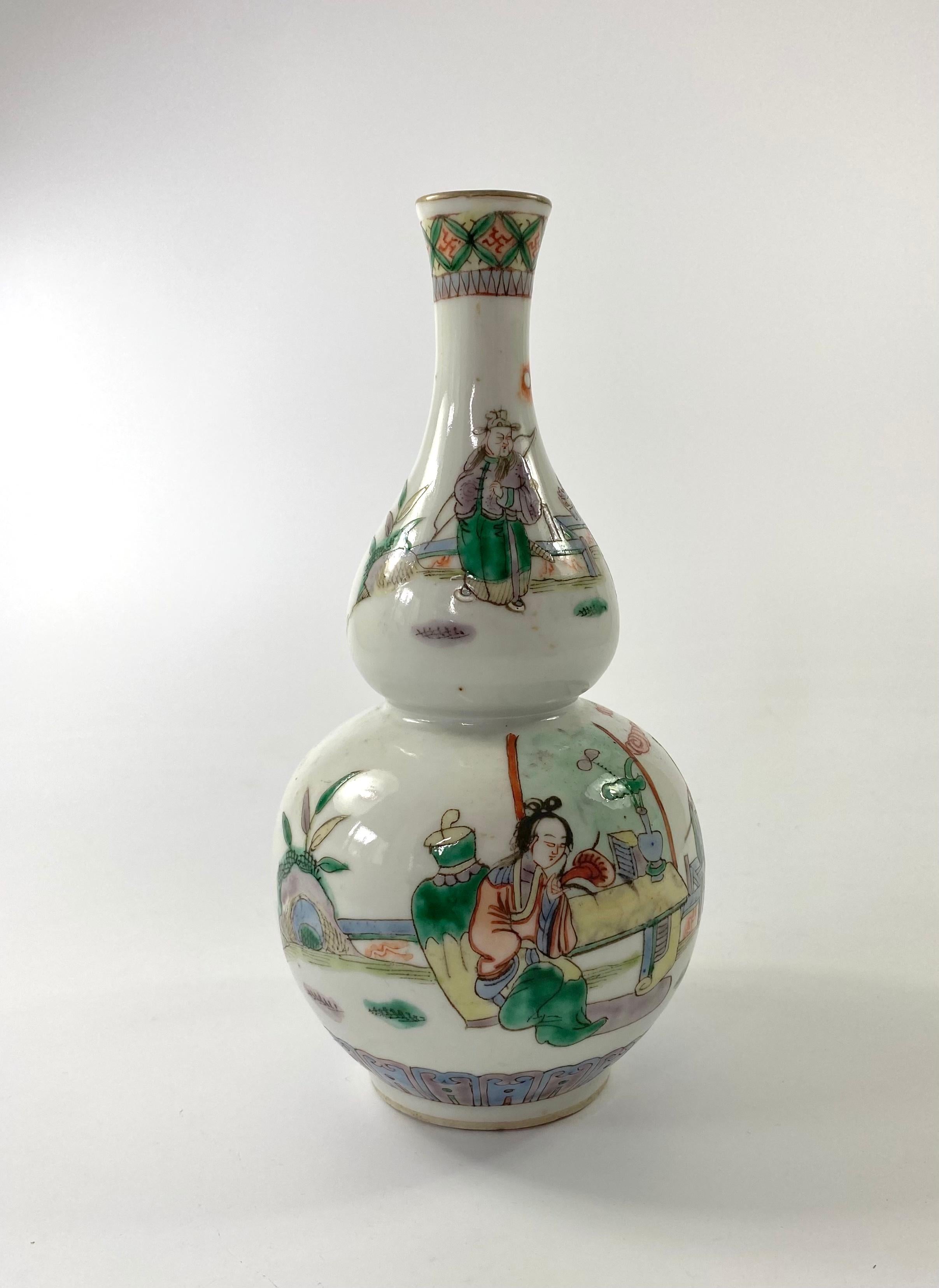 Chinese porcelain vase, bearing a retrospective four character Kangxi mark, but c. 1880, Qing Dynasty. The double gourd shaped vase, painted in famille verte or wucai enamels, with a scene of a lady gathering funghi, whilst her companion sits at a