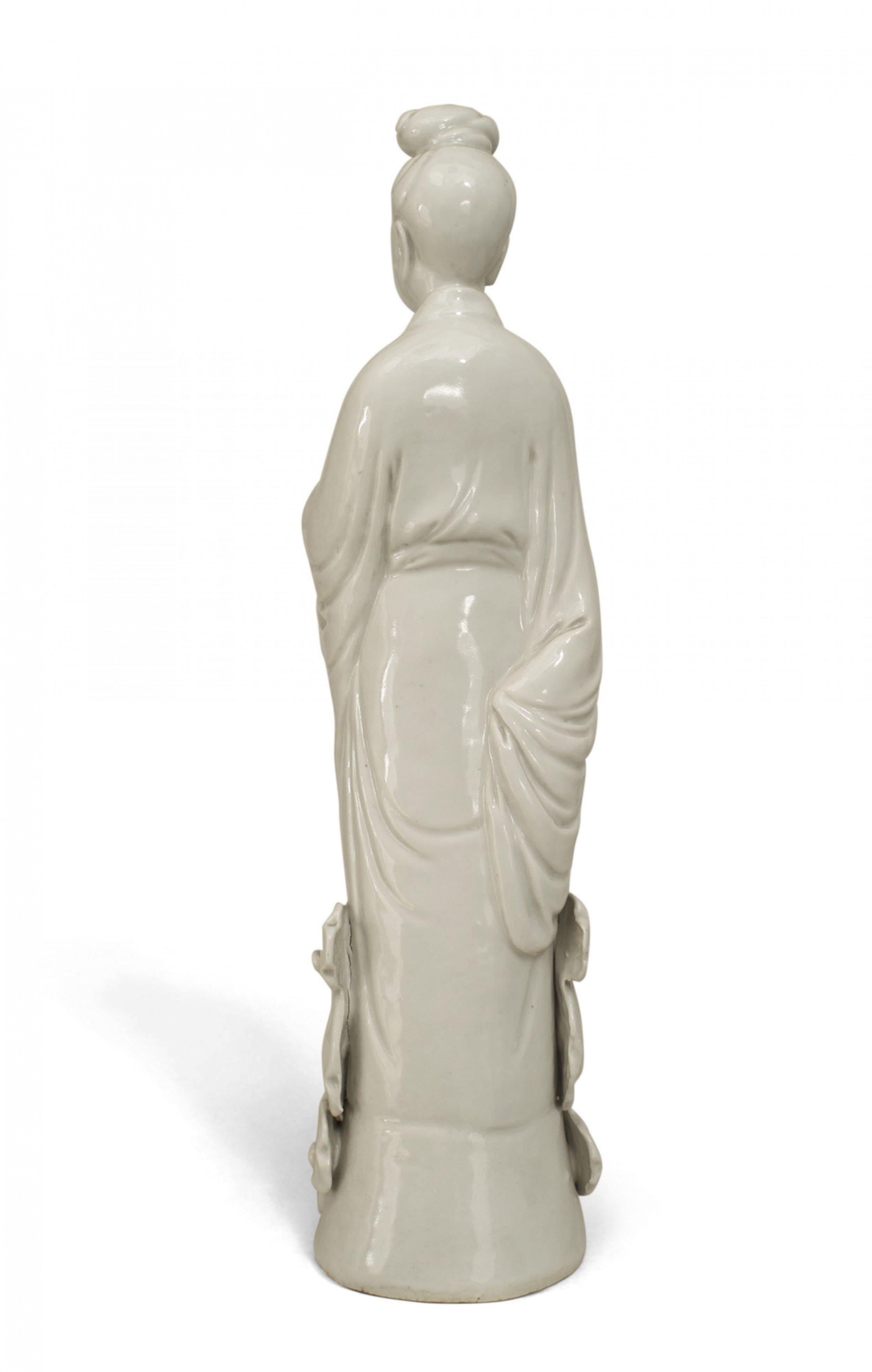 Figurine debout en porcelaine blanche de style asiatique chinois représentant une femme debout sur des nuages, peut-être une figurine d'altération.
 