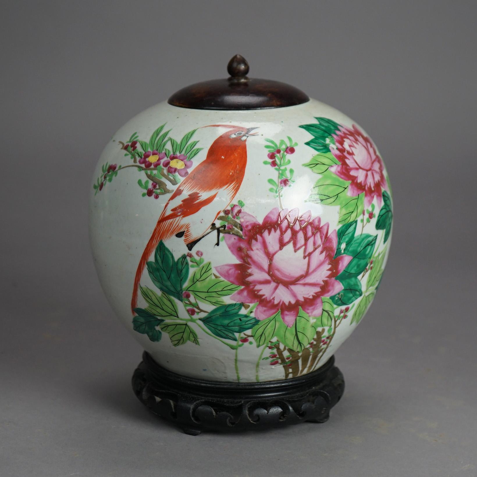A Chinese urn offers porcelain construction with garden scene having flowers and a bird, en verso symbols; metal lid, base stamp and raised on carved hardwood base, 20th century

Measures - 10