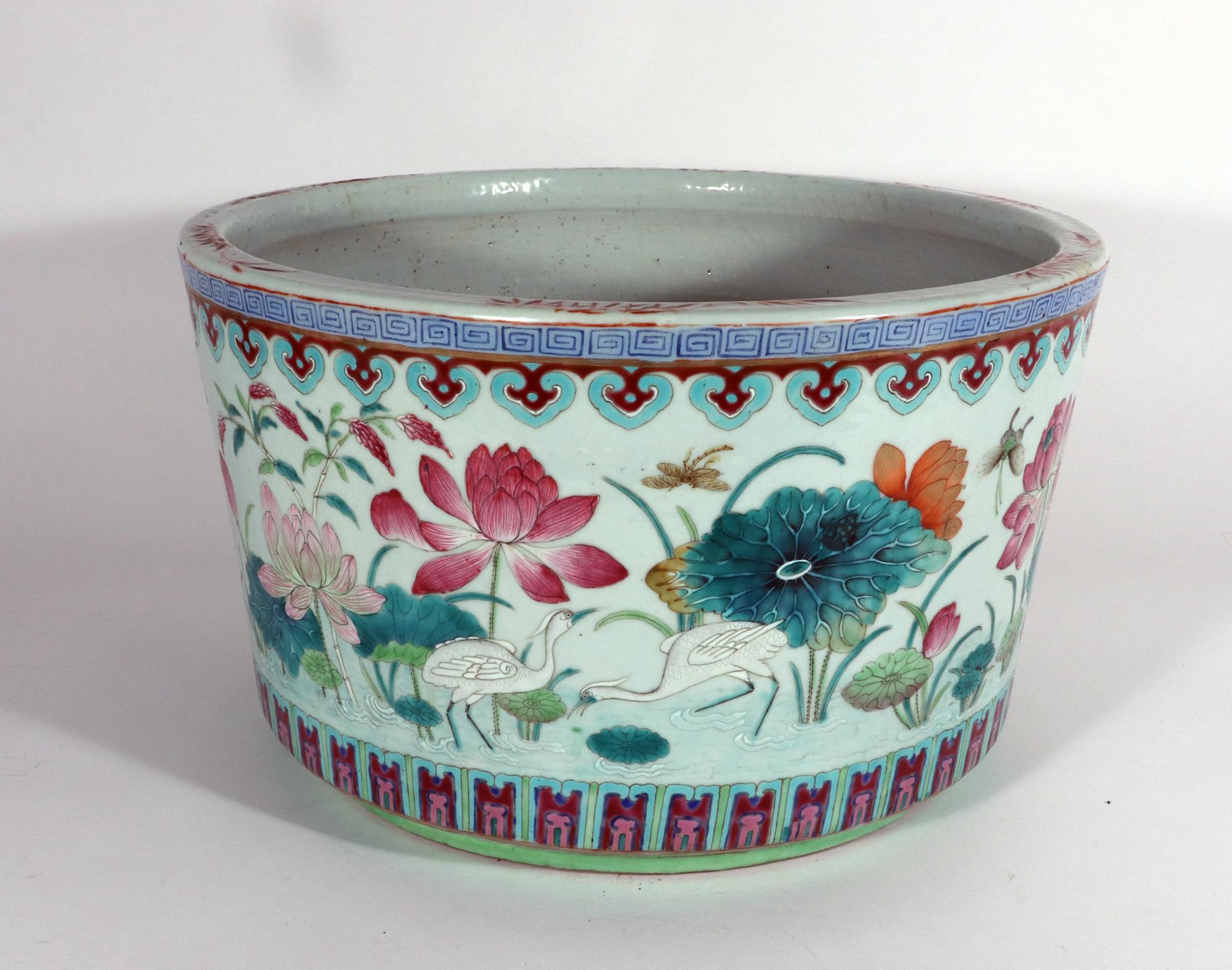 Chinese Porcelain Large Jardiniere
Mid-19th Century

The Chinese porcelain planter or jardiniere has an unglazed interior with a drainage hole.  The exterior with a continuous scene of famille rose lotus flowers and leaves in a pond with several