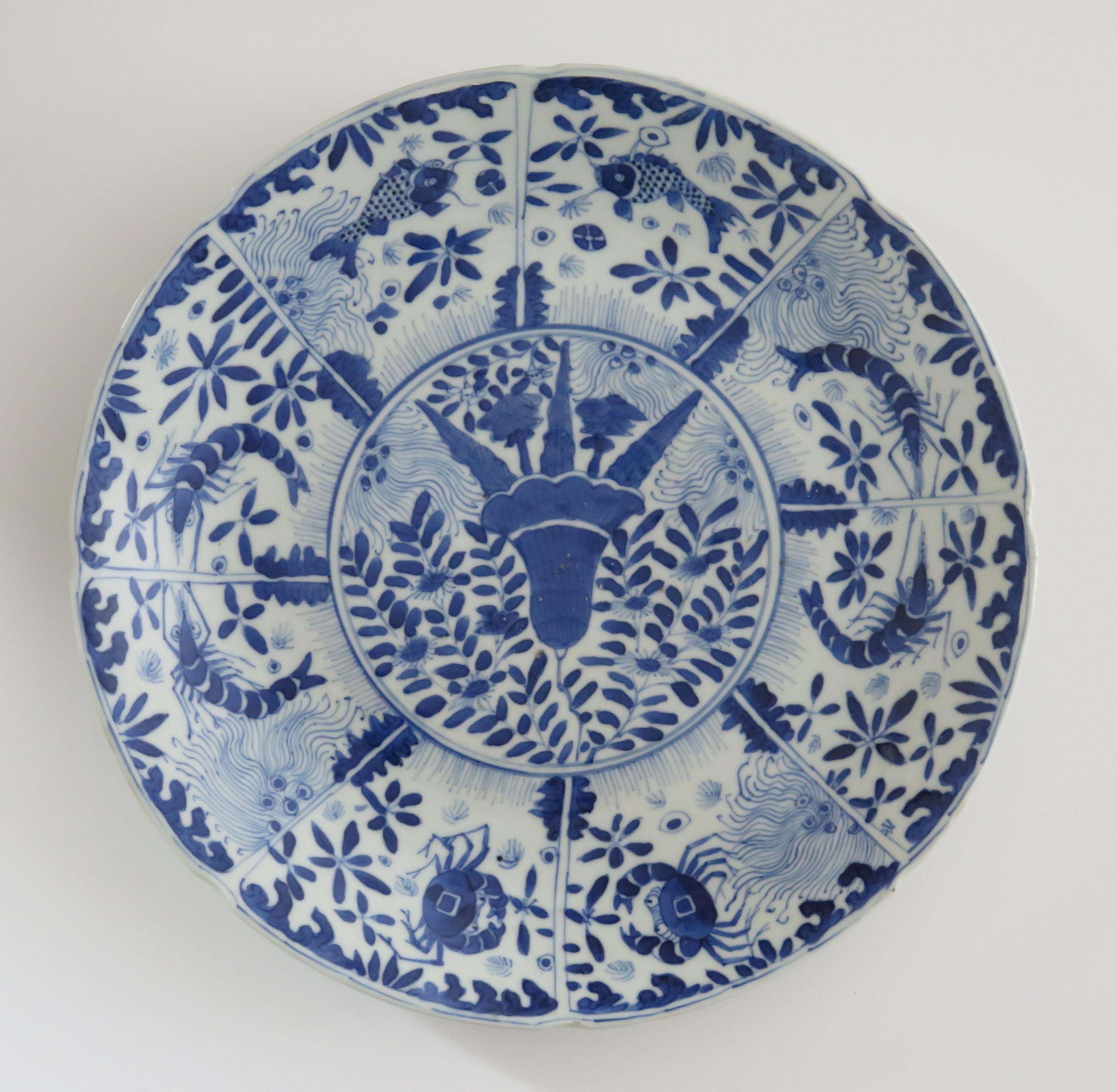 Dies ist eine schöne handbemalte, blau-weiße chinesische Porzellanschale oder -teller mit großem Durchmesser, die wir auf das frühe 19. Jahrhundert der Qing-Dynastie datieren.

Der Teller ist gut getöpfert, hat einen gekerbten Außenrand und eine