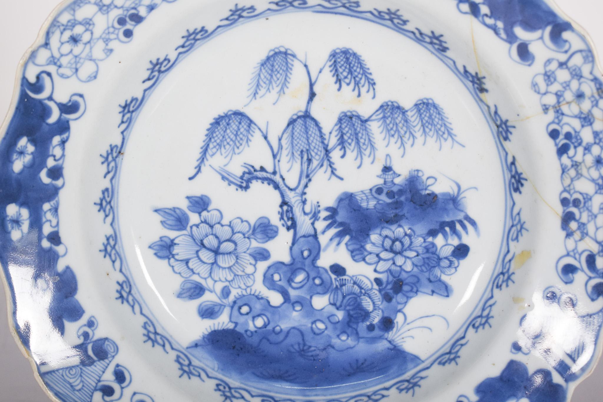 Chinese porcelain plate for export. Blue and white decoration, representing a river landscape, with plant motifs, boats, bridge and pagoda. Qing Dynasty, Qianlong period (1736-1795).
In the center, a slender willow tree sprouts gracefully behind