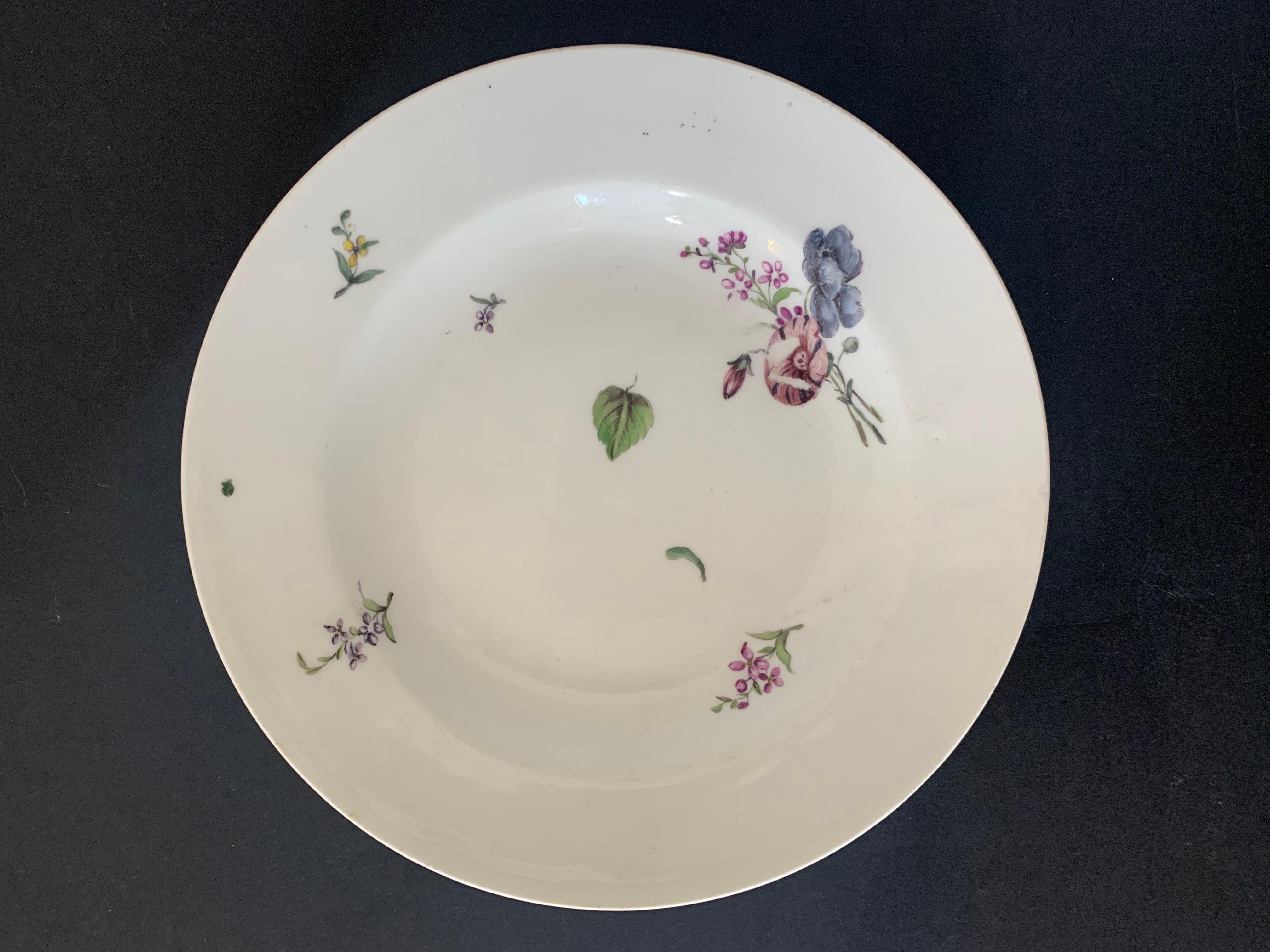 Beautiful small white porcelain plate decorated with different flowers such as petunias and phlox. Leaves seem to fly. A small plum is hidden on the back of the plate. We discover a work of extreme finesse. The lines are very fine and delicate.