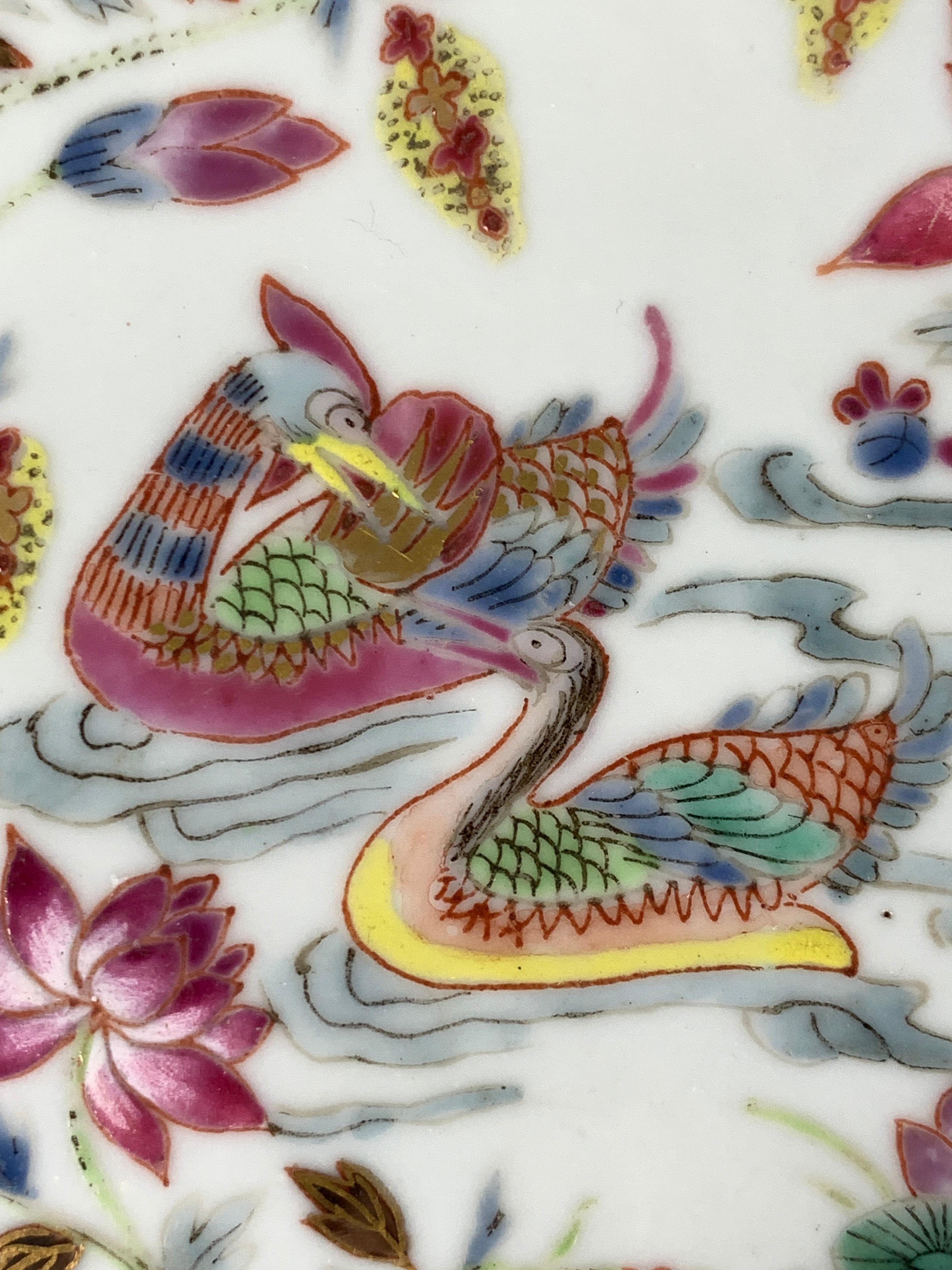 Réalisée au début du XIXe siècle, vers 1820, cette assiette de Canton rose est peinte à la main de huit immortels taoïstes, certains chevauchant de fabuleuses bêtes mythiques. La bordure est également décorée de motifs floraux. 
Un motif rose en nid
