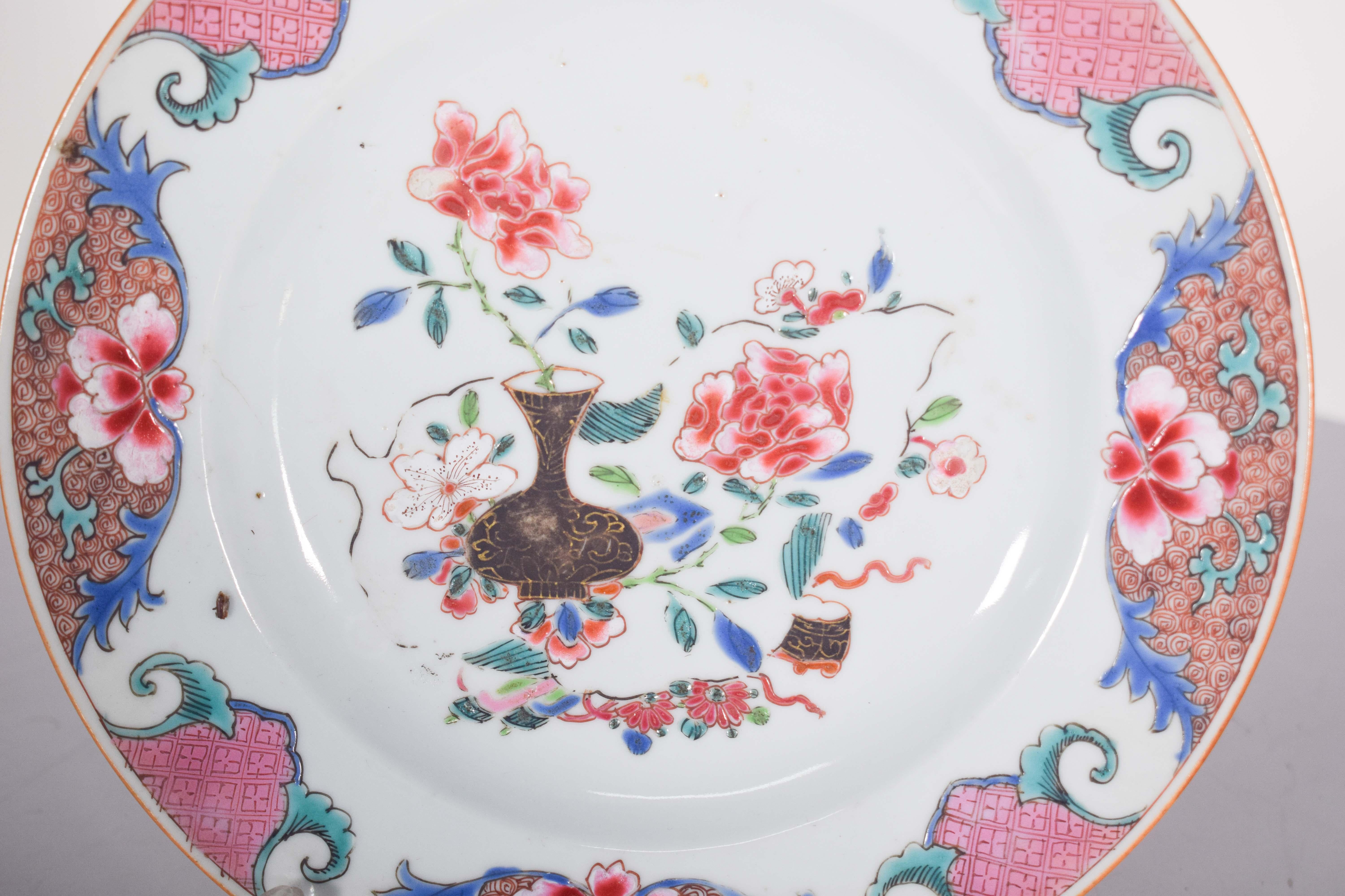 Chinese porcelain plate for export. Qing Dynasty, Qianlong period (1736-1795). 
Polychrome decoration, featuring an elegant floral composition in the center, with an ornate dark vase containing branches of red peony flowers and green leaves,