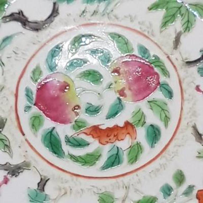 Chinese porcelain plate with scalloped edge. Daoguang period and mark (1820-1850). Center with bat and peaches, around the center a variety of blossoming flowers and their leaves. The scalloped edge is gold painted and has a small burning flaw. Back
