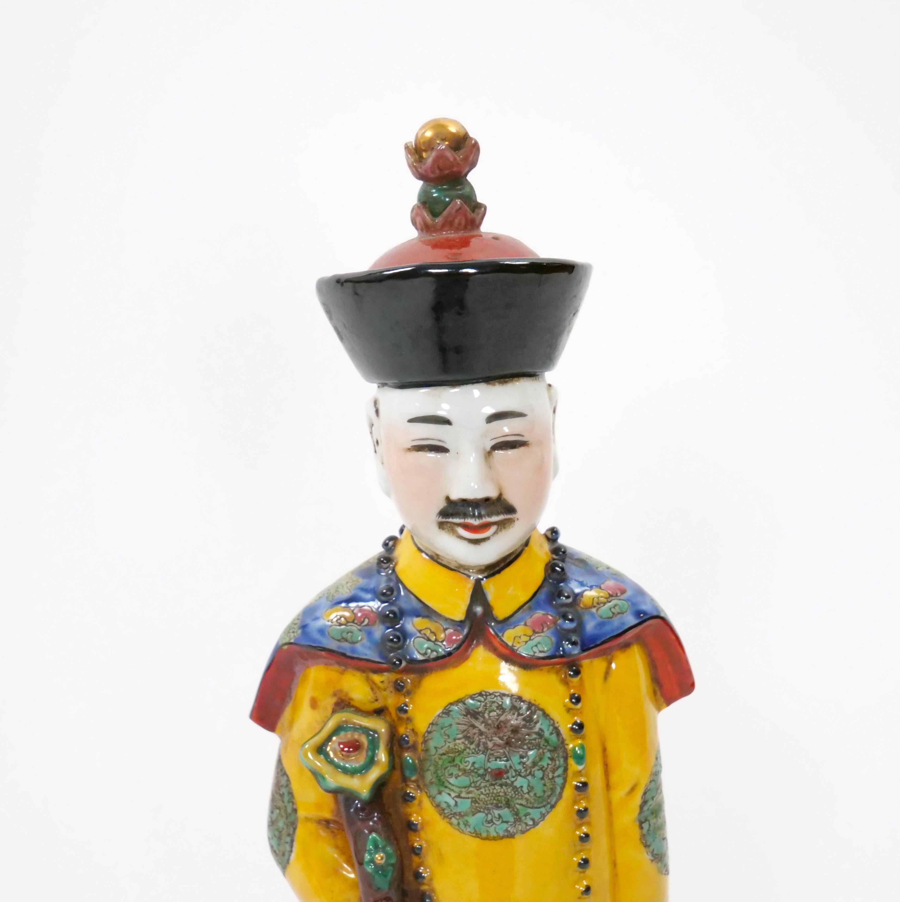 Elevate your collection with this exquisite Chinese porcelain figurine inspired by the illustrious Qing dynasty. Crafted in a stunning wucai style, the figurine depicts a distinguished emperor, regal royal, or a majestic monarch adorned in