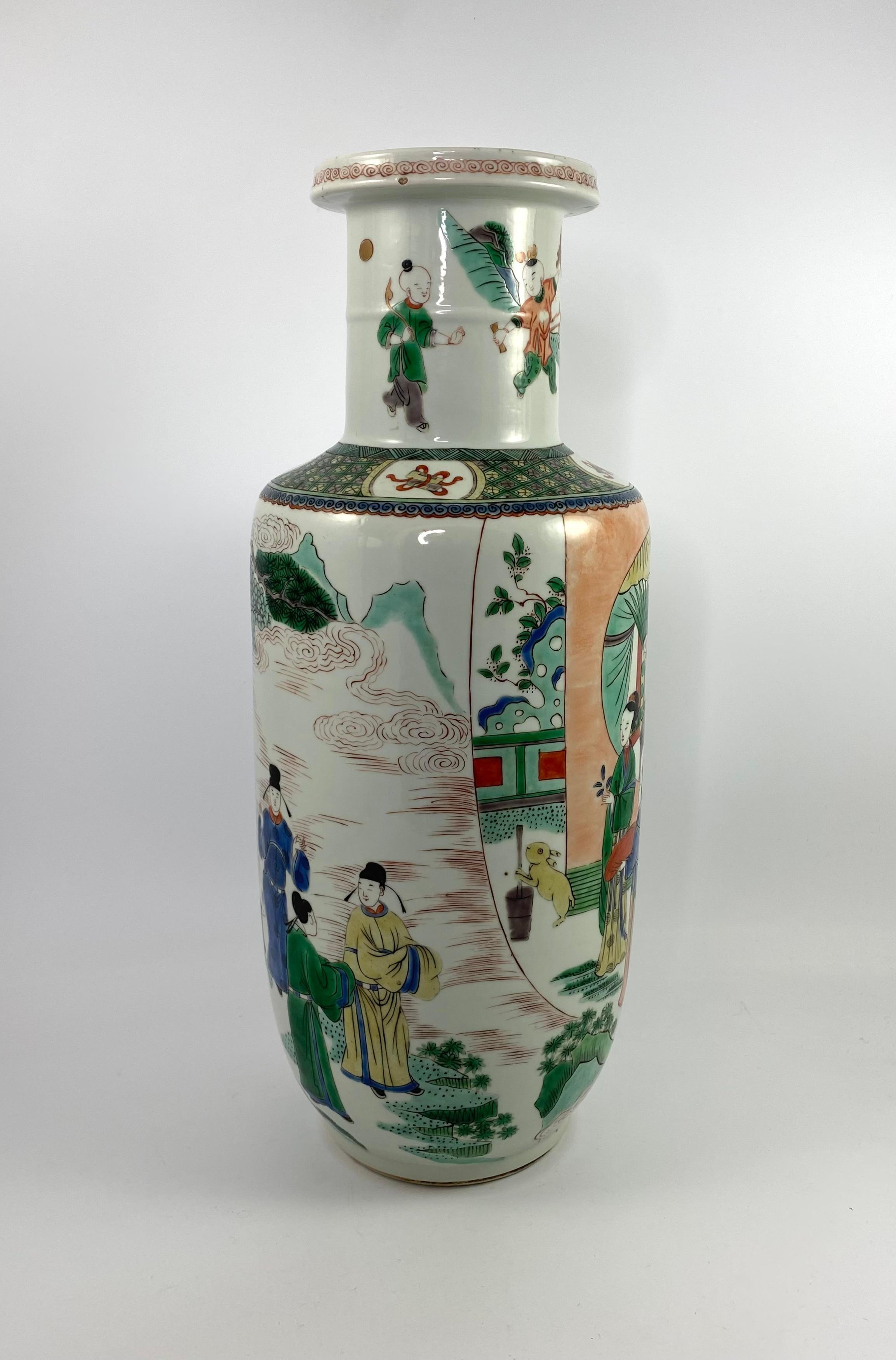 Chinese porcelain ‘rouleau’ vase, 19th Century, Qing Dynasty. The vase well painted in wucai or famille verte enamels, with a panel of ladies, observing a rabbit, in a garden, before a pavilion. A group of four men converse, before trees, and a