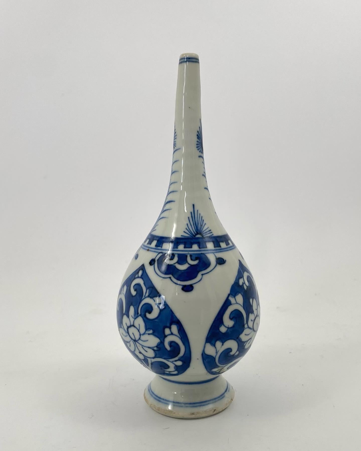 Chinese porcelain rose water sprinkler, c. 1700, Kangxi Period. The Islamic Market sprinkler, painted with shaped panels of floral scroll, in underglaze blue. Having a shoulder painted with lappets suspended from a castellated collar, beneath