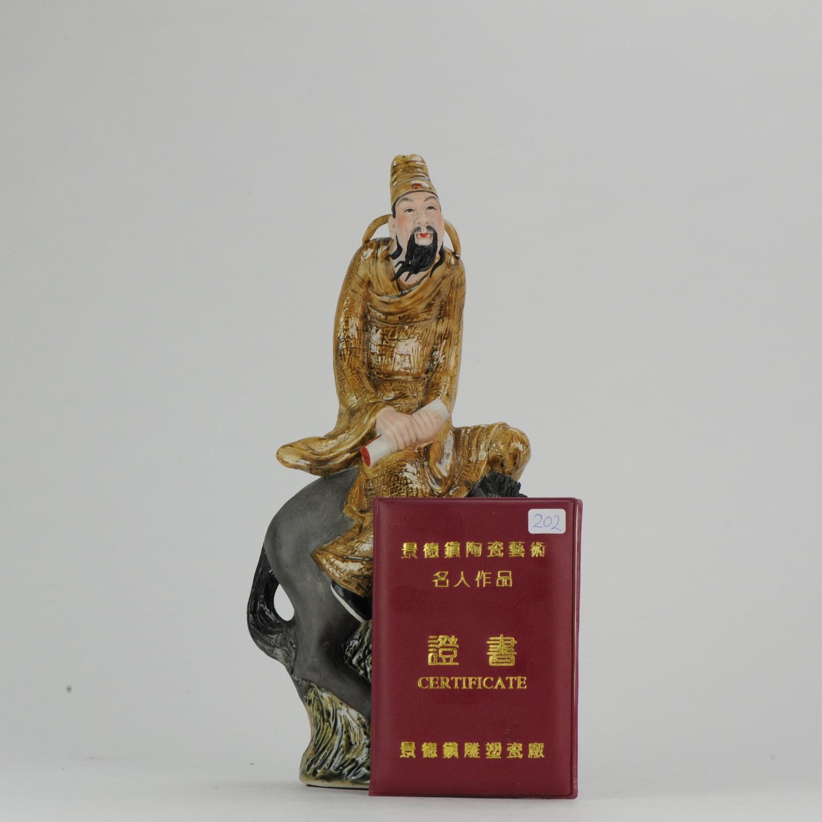 Polychrome Porzellanskulptur eines Mannes mit Schriftrolle, der auf einem Pferd sitzt. Datiert 1998. Geschaffen von Xu Jian Jian (1965), Mitglied der Künstlervereinigung von Jingdezhen. Gekennzeichnet mit Siegelmarke. China, Jingdezhen. Mit