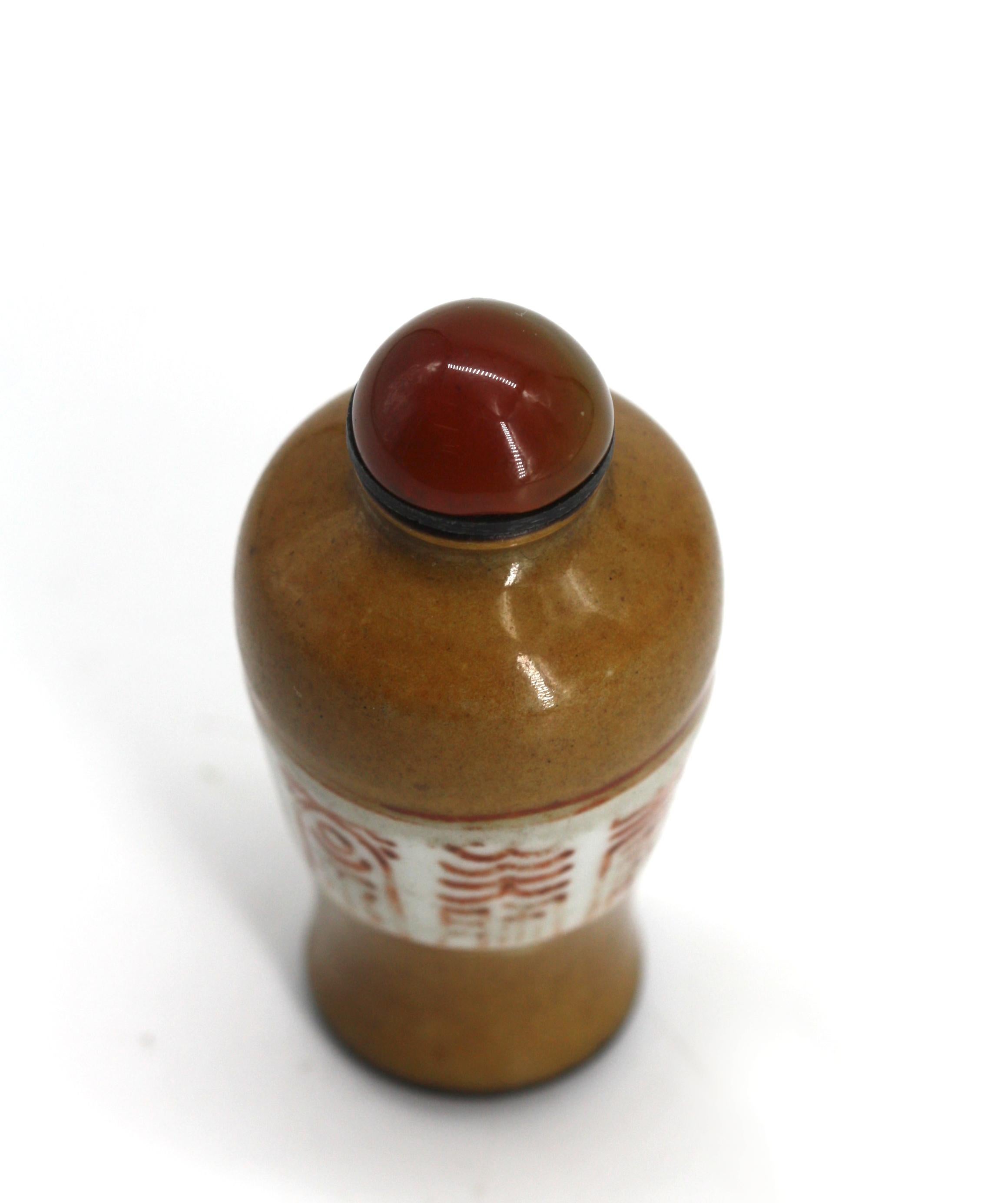 
Bouteille à priser en porcelaine chinoise
Le corps de forme balustre de couleur moka avec un large bandeau au milieu du corps peint de caractères stylisés, le capuchon en forme de dôme en agate, avec une anse.
Hauteur 2.75 in.
Rapport de