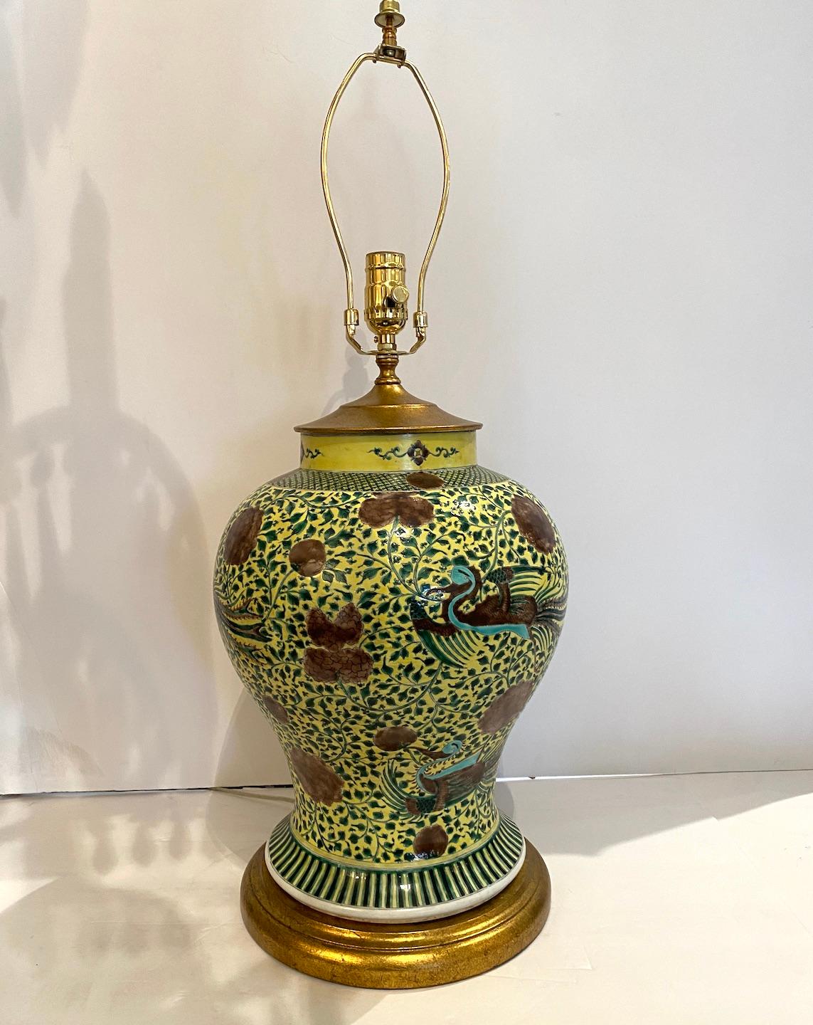 Jarre en porcelaine peinte à la main de la période de la République transformée en lampe.  Oiseaux phénix, flore et décoration feuillue sur un fond jaune vibrant.  Base en bois doré de 10