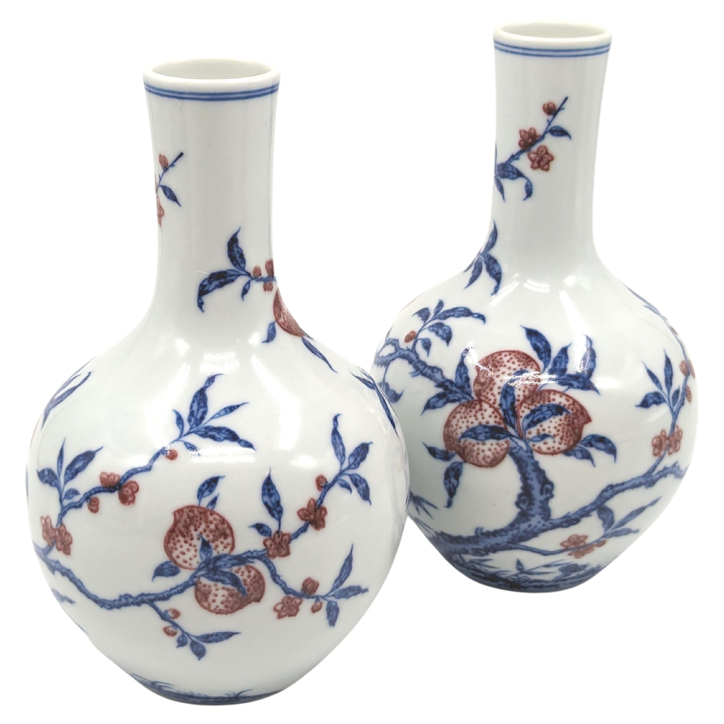 Vase bouteille à pêches en porcelaine chinoise bleu sous glaçure et rouge cuivre Fin 20e Paire