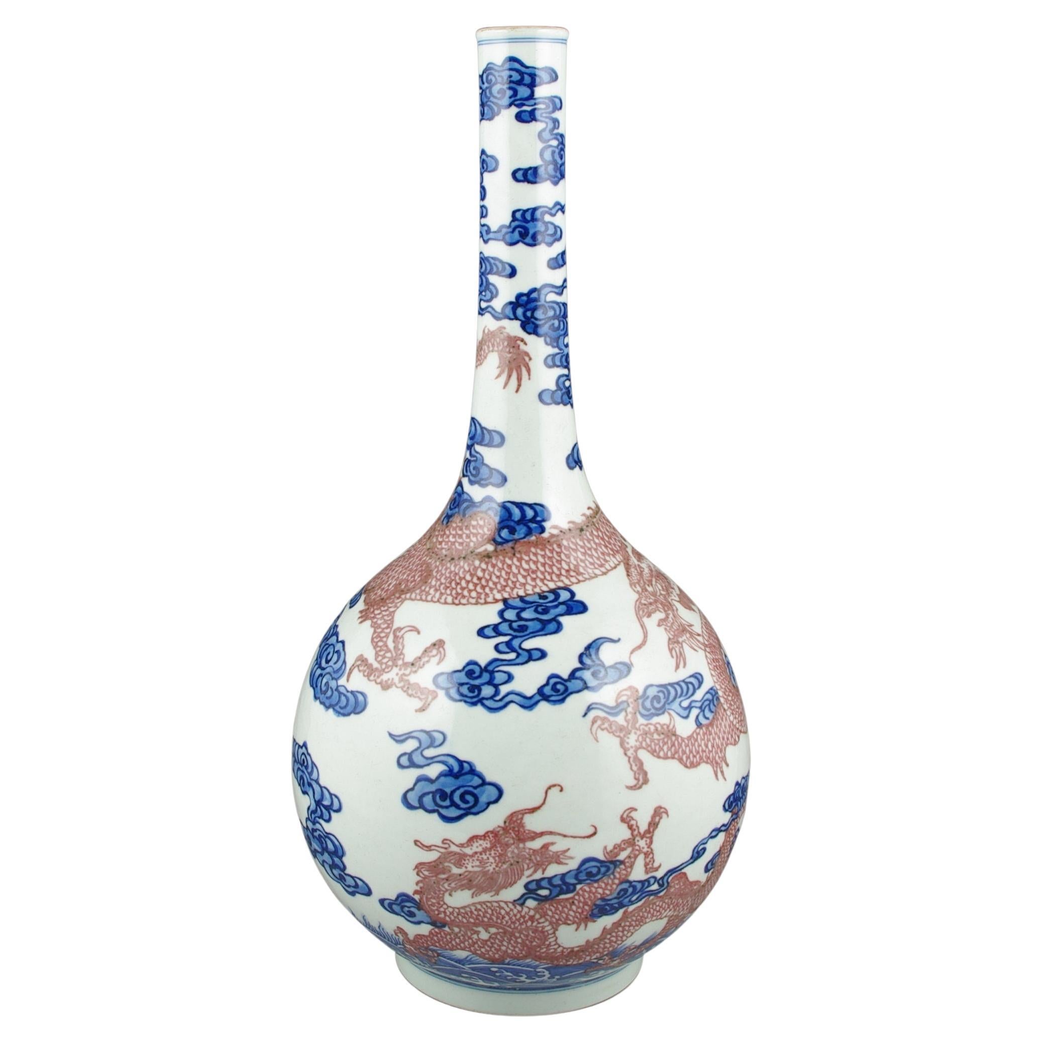 We are thrilled to present this exquisite Chinese porcelain long-neck bottle vase, a splendid representation of masterful craftsmanship and artistic tradition. The vase captivates with its intricate depiction of two scaly four-clawed dragons,