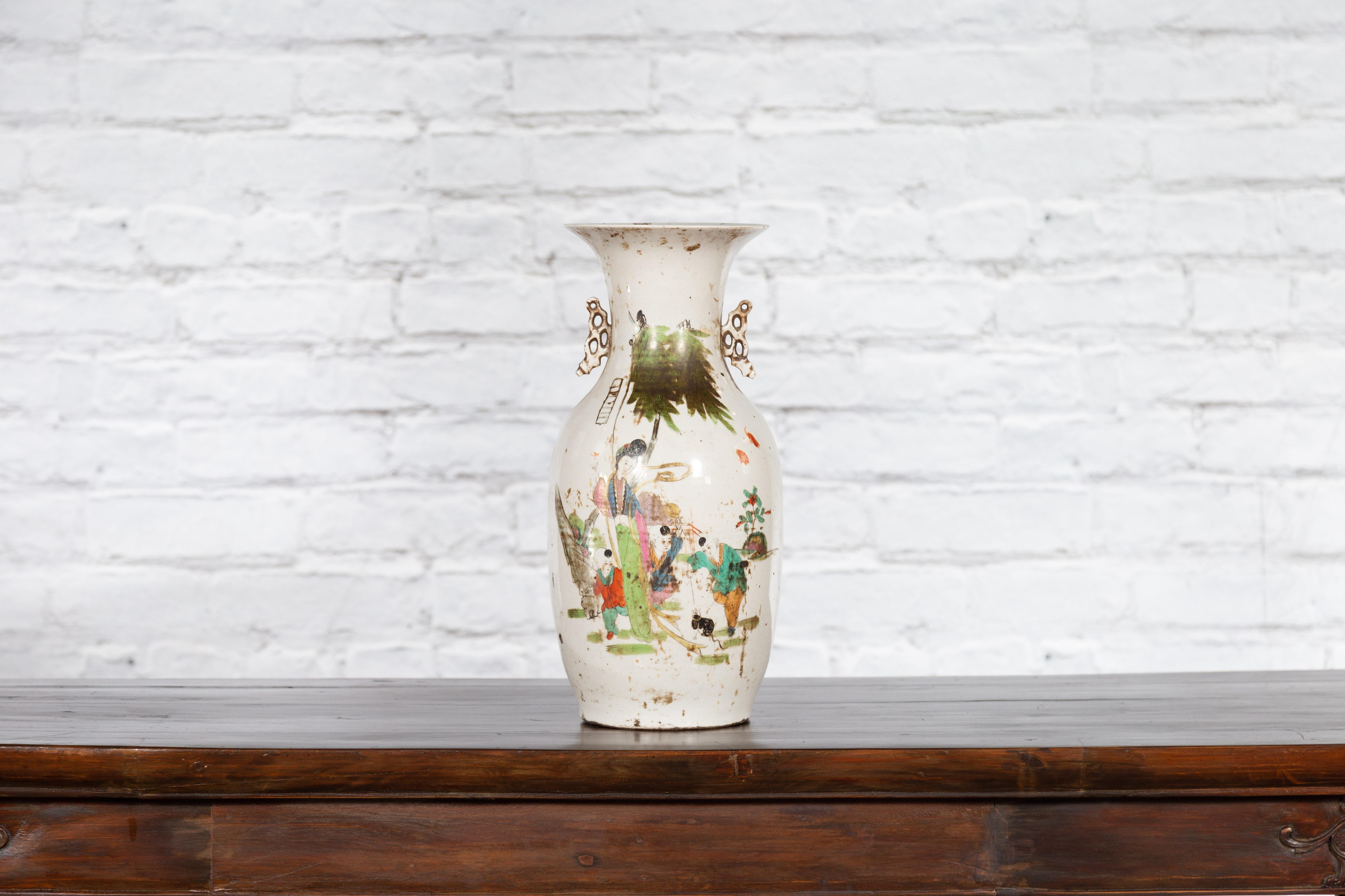 A Chinese porcelain vase with hand-painted décor and calligraphy motifs. Created in China, this porcelain vase features a nicely flaring neck flanked with petite pierced handles on the sides. The opening is 4.5