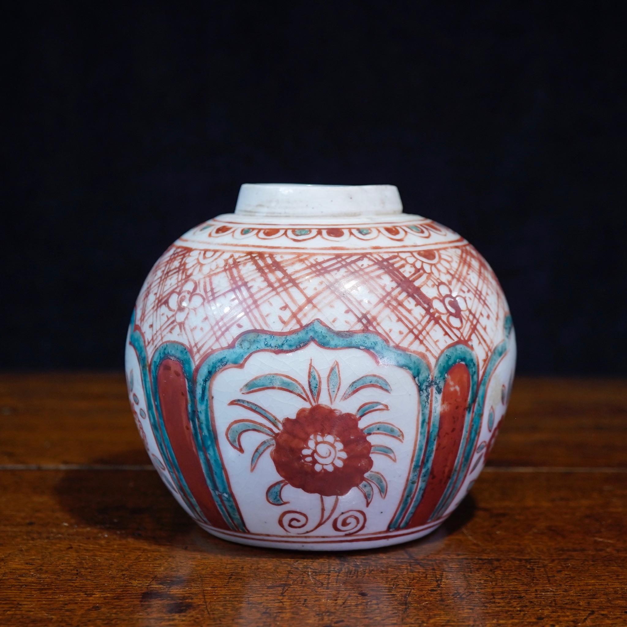Chinese porcelain 'Swatow' jar, of elegant globular form with minimal neck, painted all over in onglaze enamels with four large petal form panels of flowering plants, set on a lattice ground with petal lappet border to the rim.

18th-19th