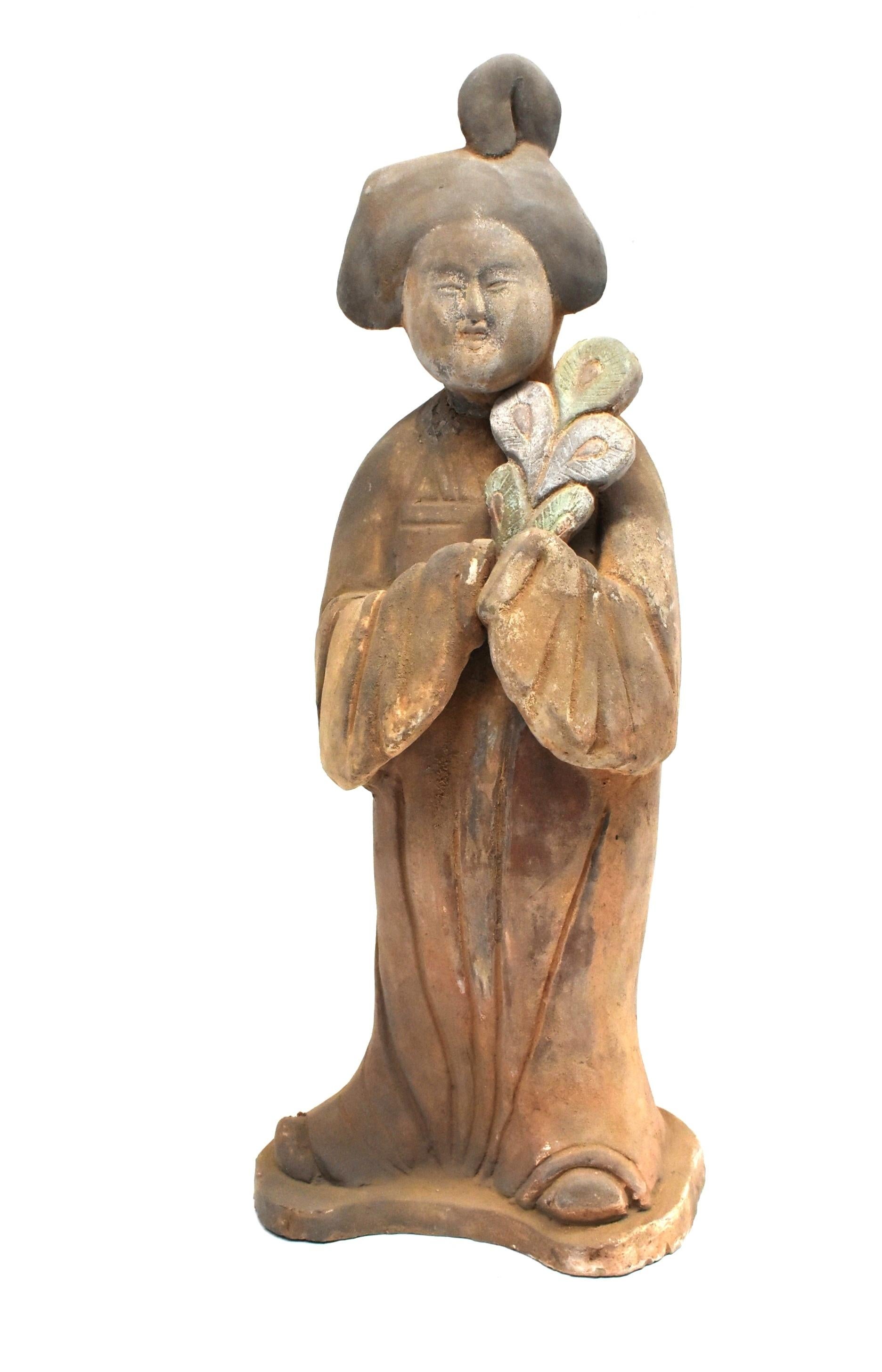 A beautiful terracotta court lady in the Tang dynasty style. Featured is a court lady holding a peacock feather. She is dressed in traditional high-waist dress with hair done in the Tang dynasty fashion. Facial features typical of the era.

 