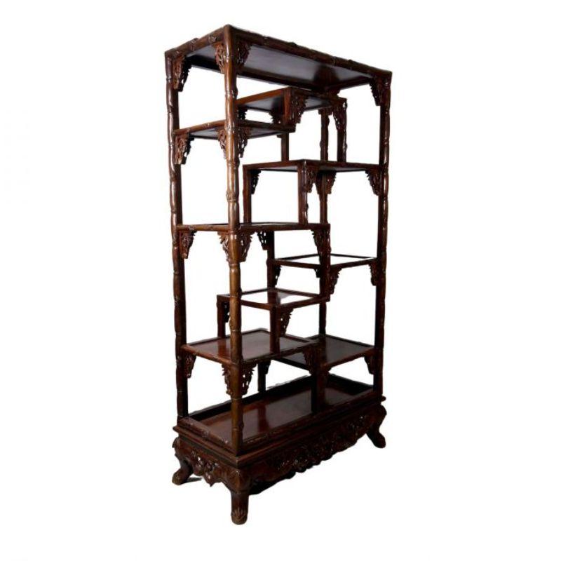 Chinese presentation shelf in carved exotic wood from the 20th century. Note that it is carved on both sides, so it can serve as a room divider. dimension height 172 cm for a width of 89 cm and a depth of 40 cm. Decor of foliage and bamboo