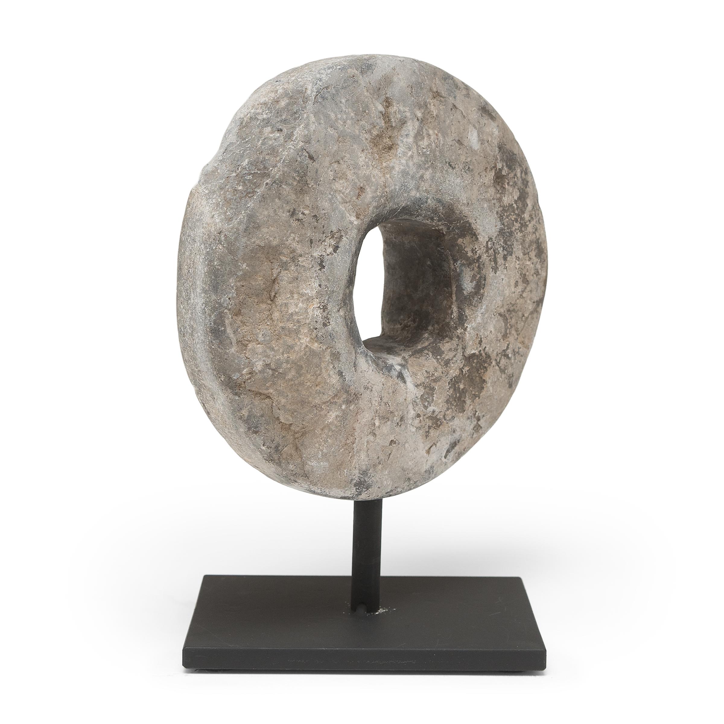 This round stone disc originated as an early 20th-century threshing wheel. Secured to a wooden axel that ran through the center, the stone was rolled across stalks of wheat to separate the grain, pulled either by man or by ox. With simplicity of