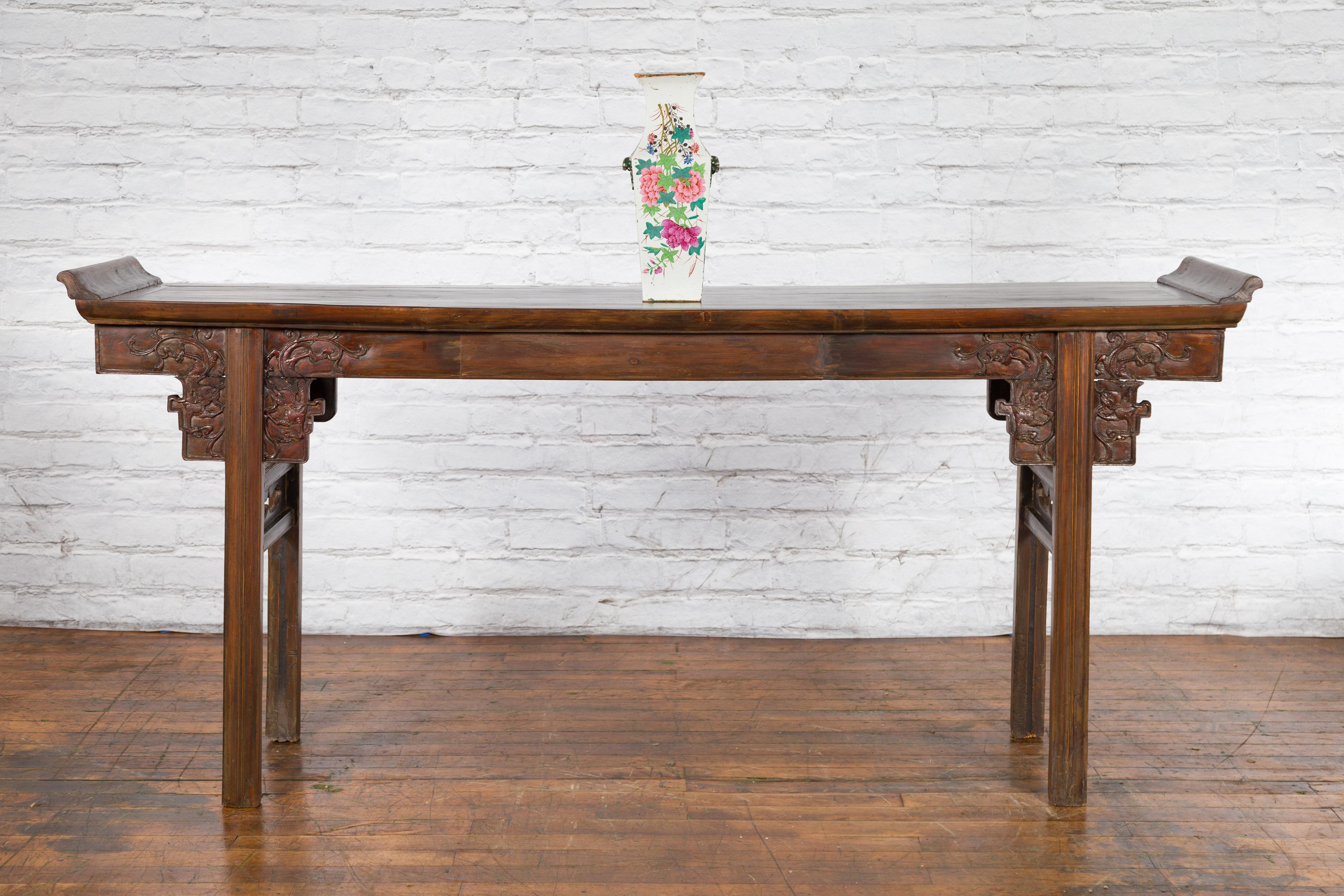 A Chinese Qing Dynasty hand-painted altar vase from the 19th century, with floral décor and gilt trim. Created in China during the Qing Dynasty, this altar vase features a narrow flaring neck showcasing an opening of 3.5