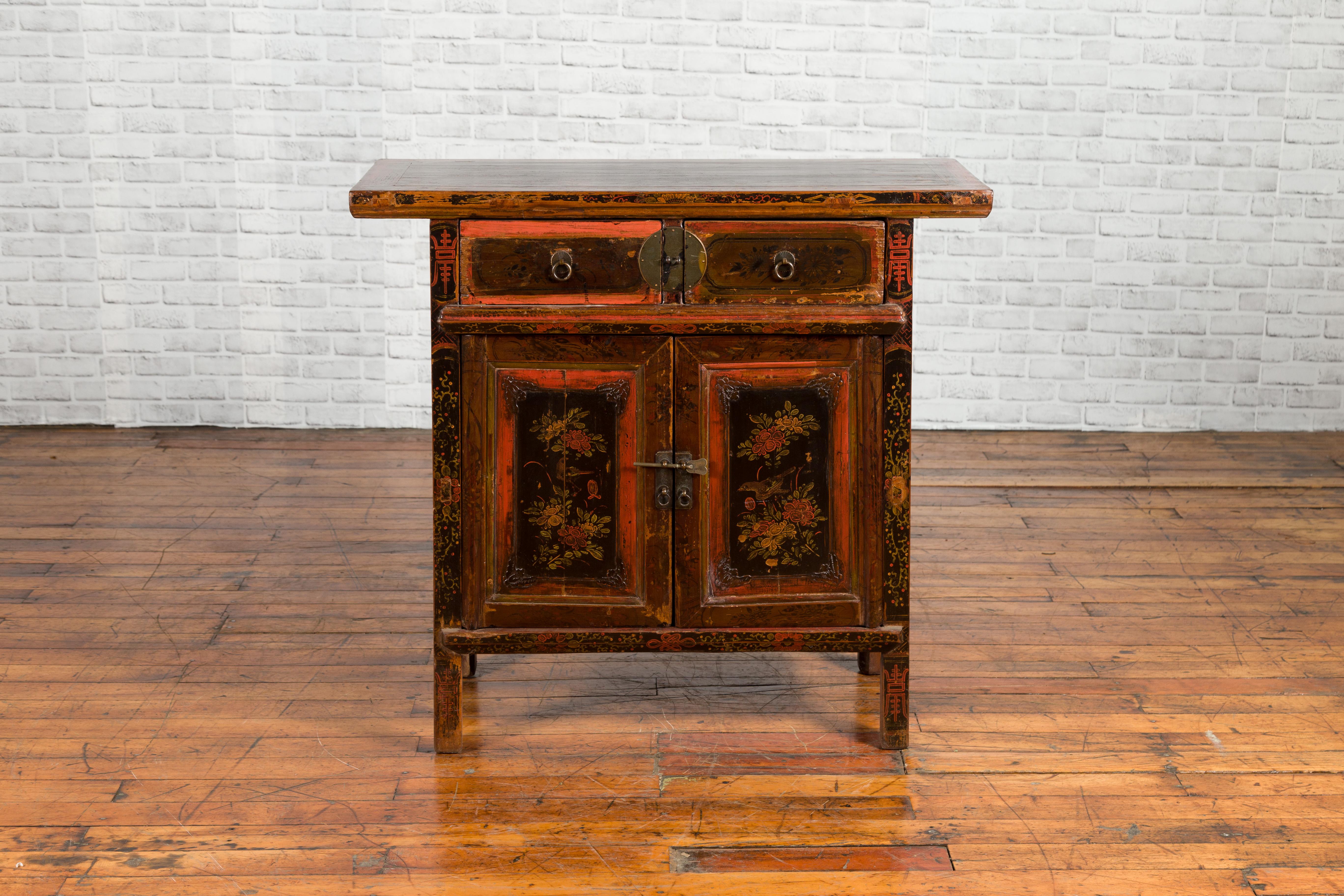 A Chinese Qing dynasty period small cabinet from the 19th century, with original brown, red and black lacquer, two drawers and two doors. Created in China during the Qing dynasty, this small cabinet features a rectangular top with nicely distressed