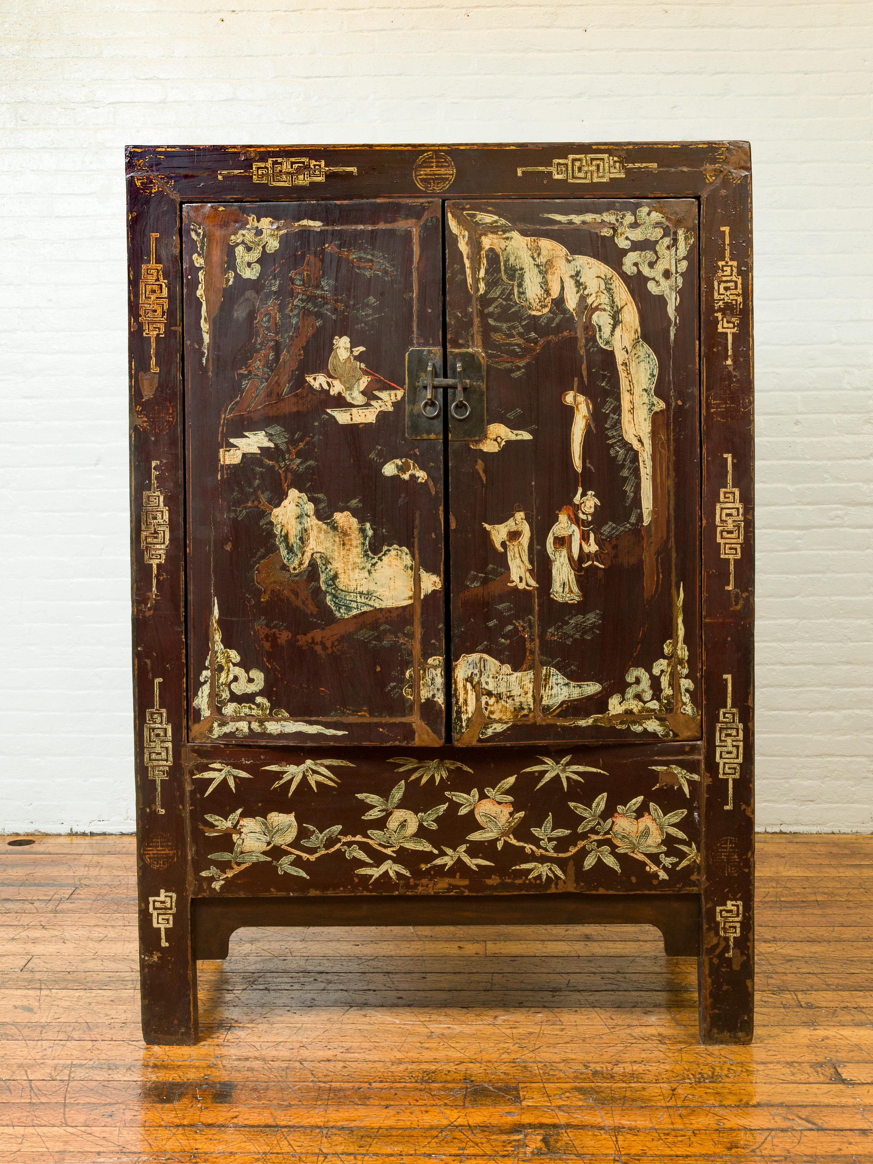 A Chinese Qing dynasty brown lacquered two-door cabinet from the early 20th century, with hand painted chinoiserie décor. Born in China during the early years of the 20th century this cabinet features a brown lacquered finish showing a nicely