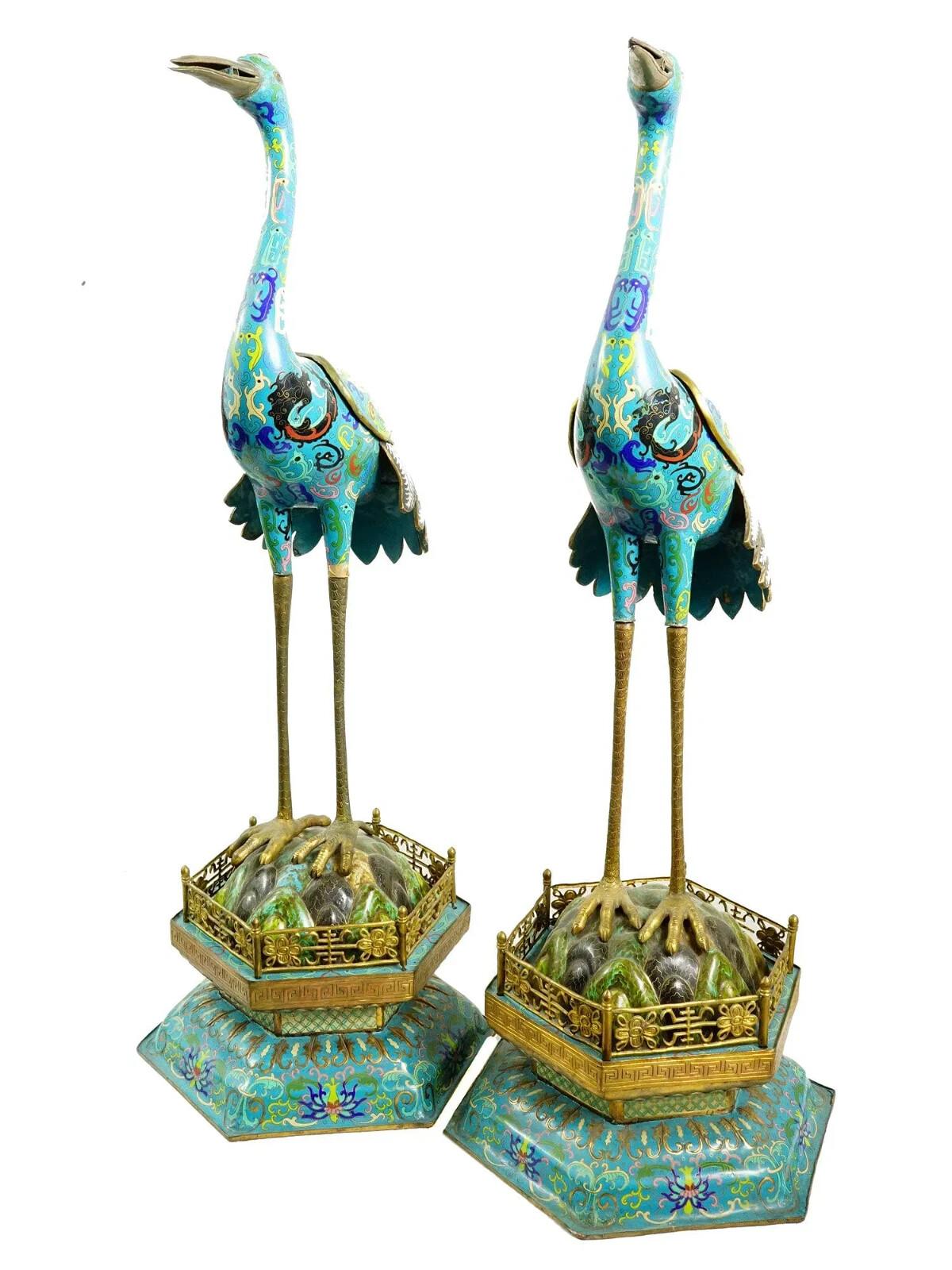 Paire de grandes figurines chinoises anciennes de grues en émail cloisonné avec un long cou et de longues jambes, dynastie Qing, 19e siècle. Le corps des grues et leur base sont décorés de motifs de feuillage et d'images de dragons en émail