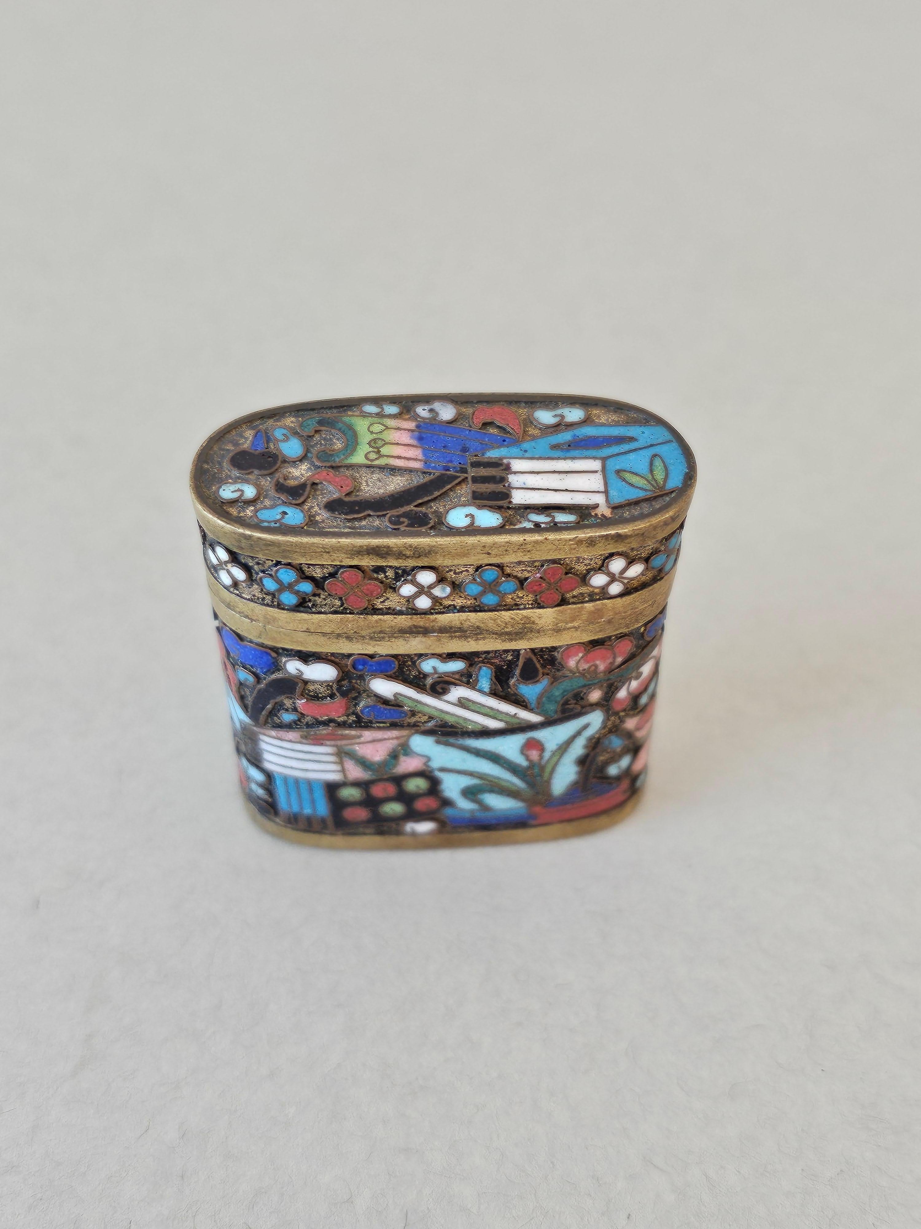 A rare, interesting, and a bit unusual Qing Dynasty (1636-1912) Cloisonné enamel opium box. 

Originating in China in the 19th century, small lidded oval shaped polychrome enameled bronze opium case with blue interior and bottom. Decorative and