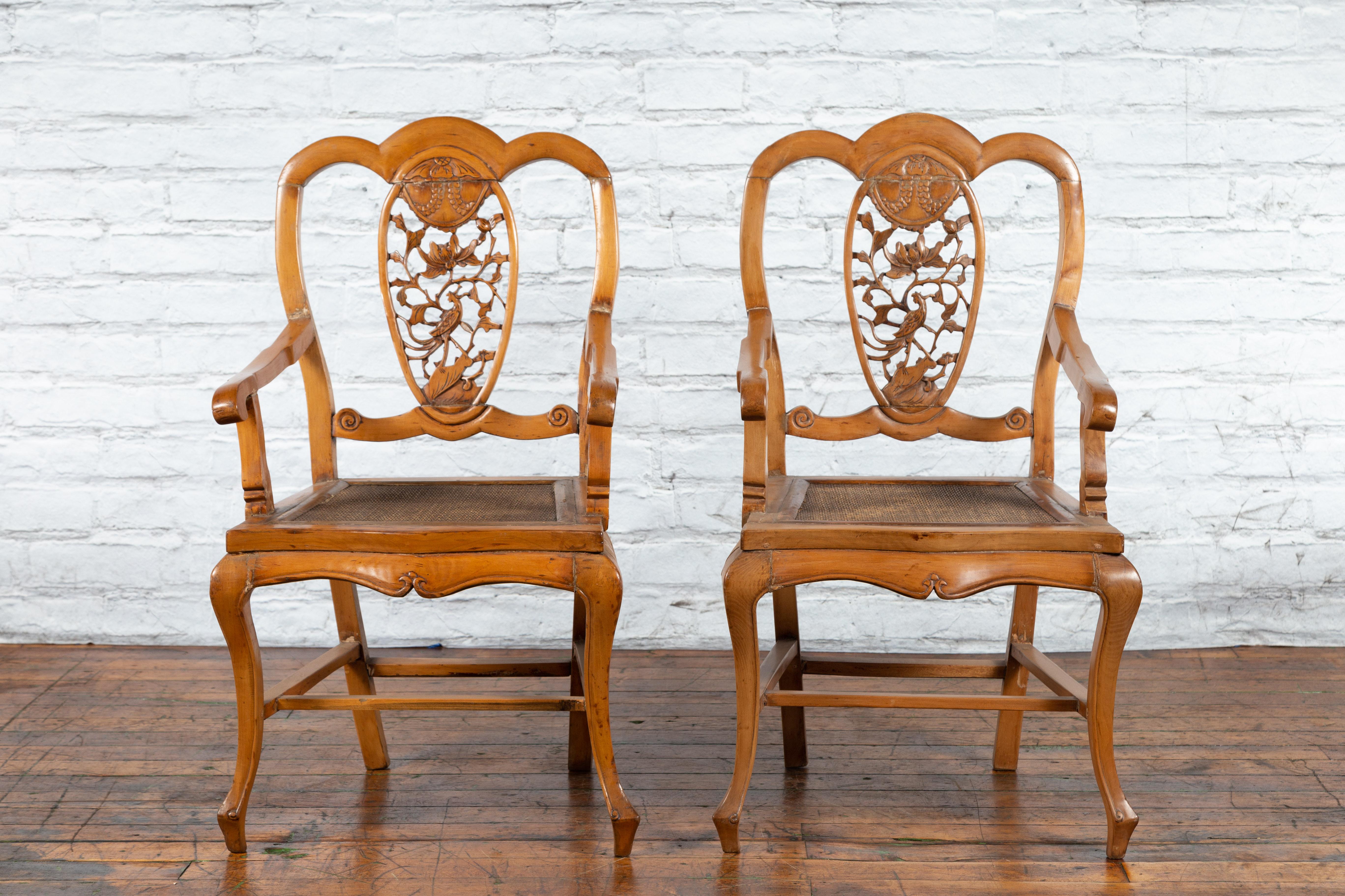 Two Chinese Qing Dynasty period carved wooden armchairs from the 19th century with hand-carved medallion, priced and sold each. Created in China during the Qing Dynasty period, each chair features a carved splat adorned with a hand-carved oval