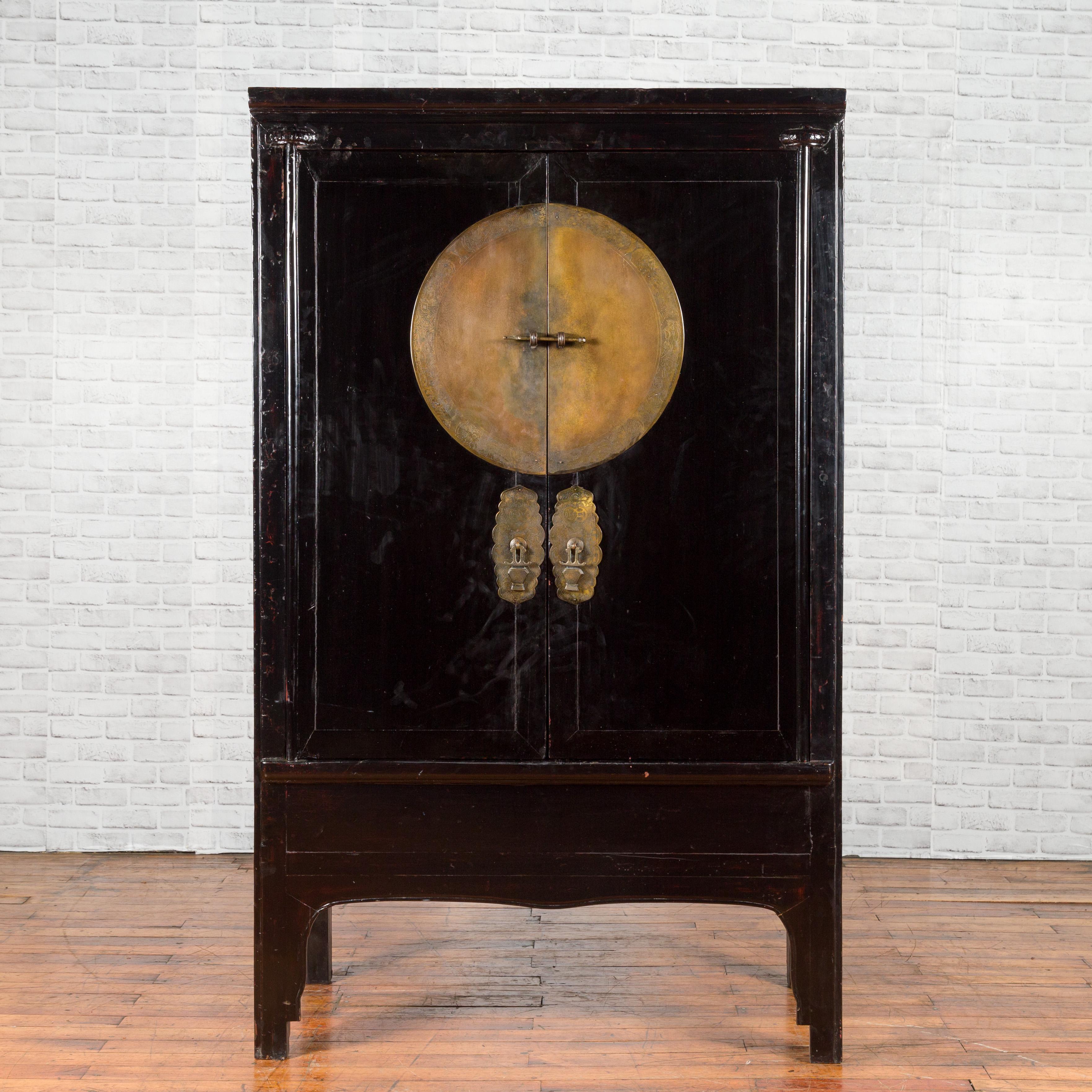 A Chinese Qing Dynasty black lacquer cabinet from the 19th century, with large medallion hardware, inner drawers and removable panel. Created in China during the Qing Dynasty, this black lacquer cabinet features two doors, fitted with a very large