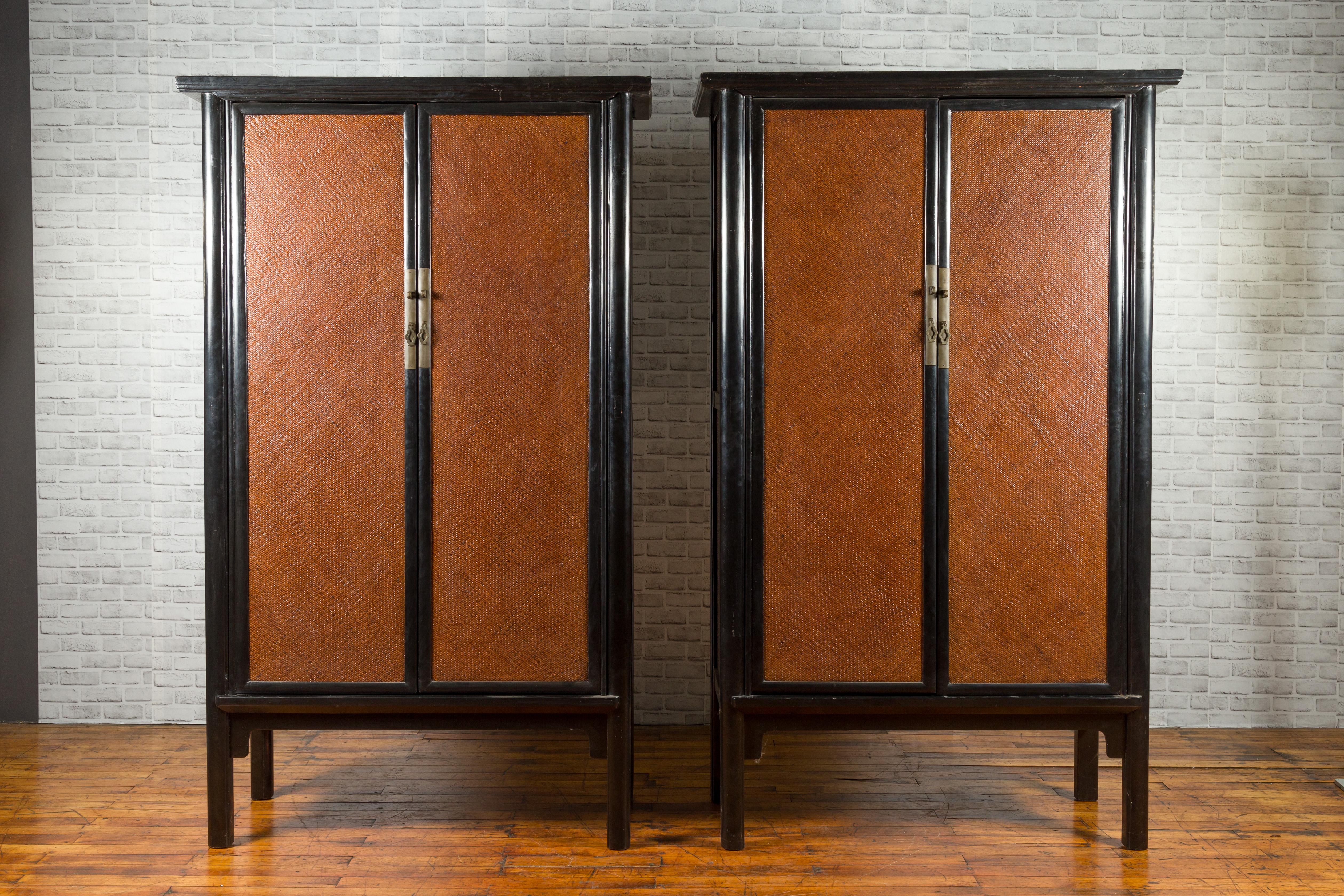 A Chinese Qing Dynasty period black lacquered cabinet from the 19th century, with woven rattan doors. We have two available that will make for a great pair. They are priced $5,800 each. Created in China during the Qing Dynasty, each cabinet features