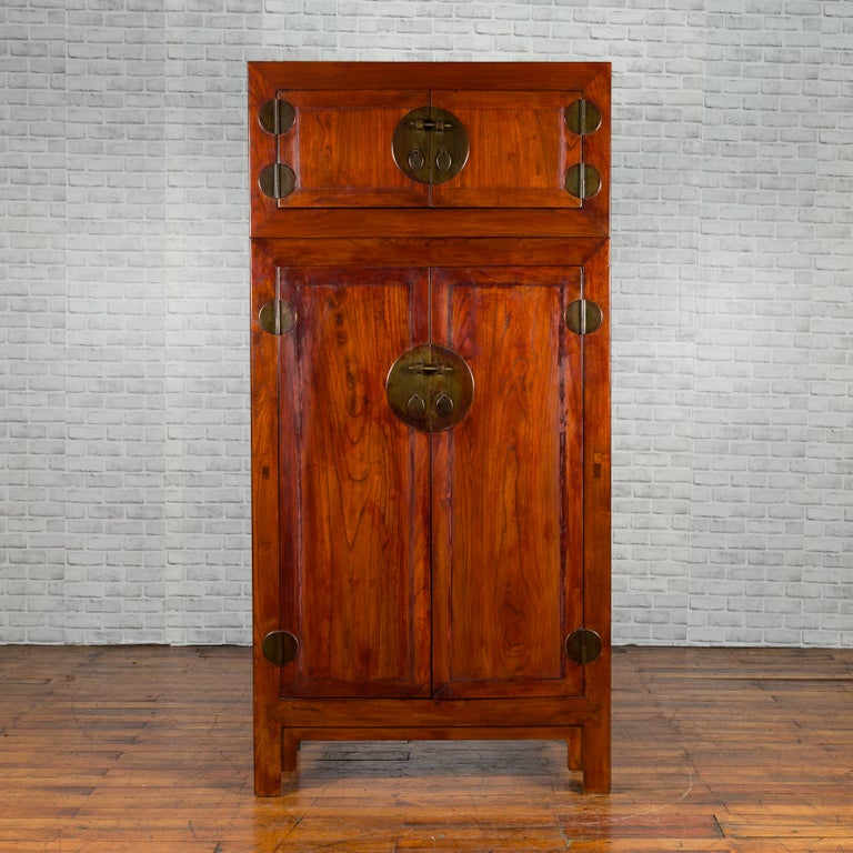 A Chinese Qing Dynasty period compound cabinet from the 19th century, with two drawers and brass medallion. We currently have two available, priced and sold $6,500 each. Created in China during the Qing dynasty, this compound cabinet features a