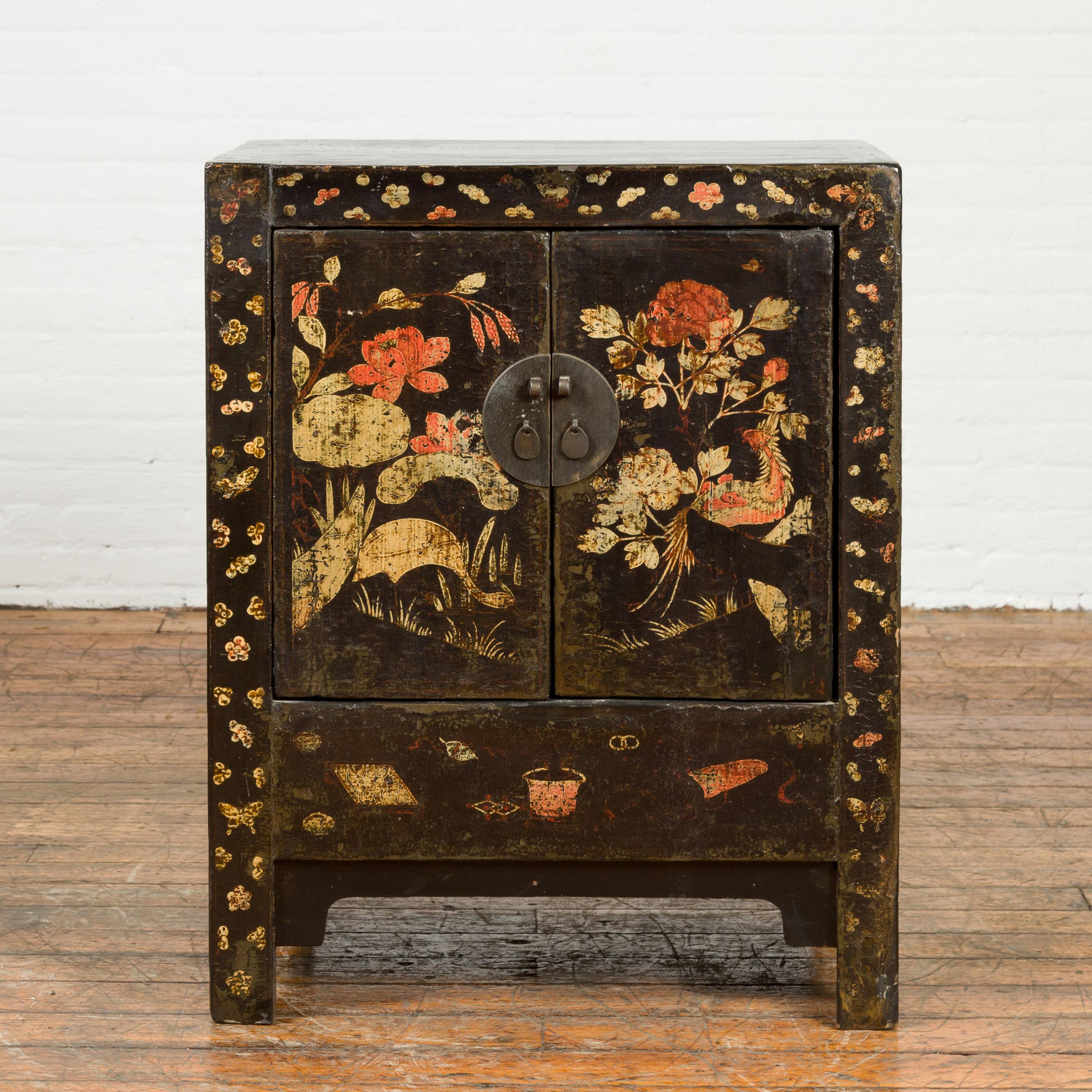 A Chinese Qing Dynasty period side cabinet from the 19th century, with original décor. Created in China during the Qing Dynasty, this side cabinet features a rectangular top sitting above a façade showcasing its original décor standing out