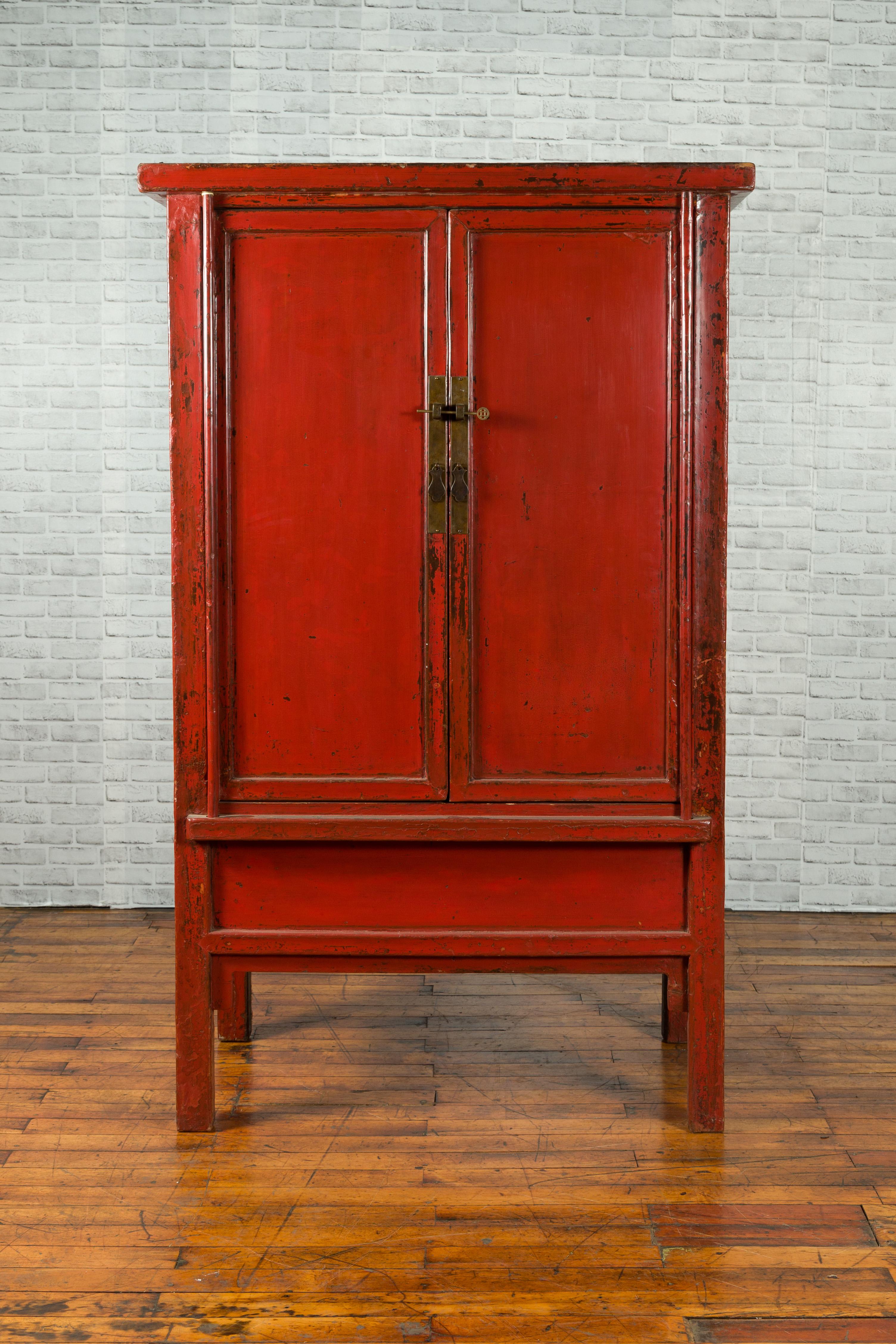 A North-Eastern Chinese Qing Dynasty 19th century elmwood cabinet from Shanxi with two doors and original red lacquer. Created in China during the Qing Dynasty, this red lacquered cabinet features two simple doors opening thanks to a brass lock to