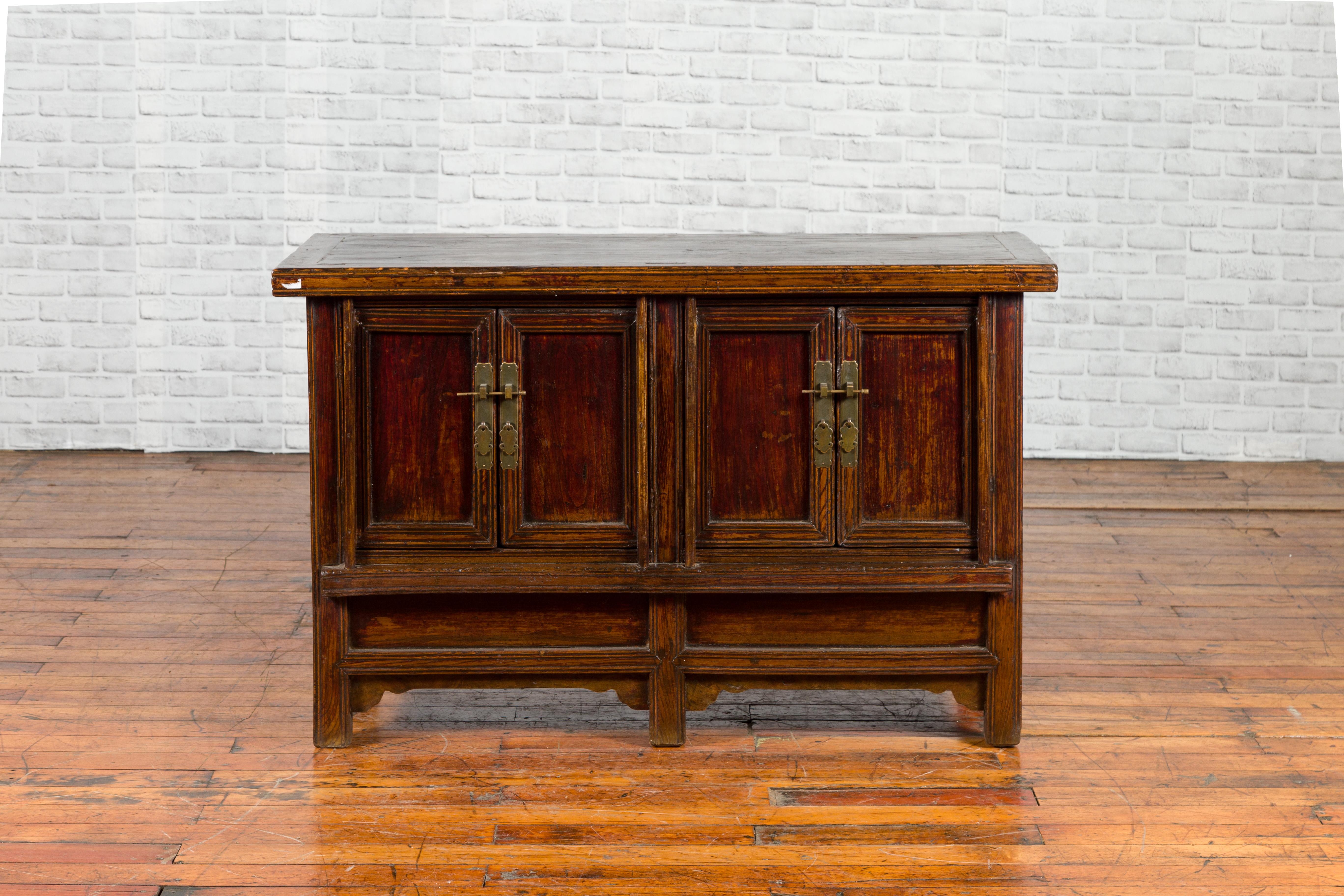 A Chinese Qing Dynasty period side cabinet from the 19th century, with brown lacquer and two pairs of double doors. Created in China during the Qing Dynasty period, this side cabinet features a rectangular top with central board and distressed